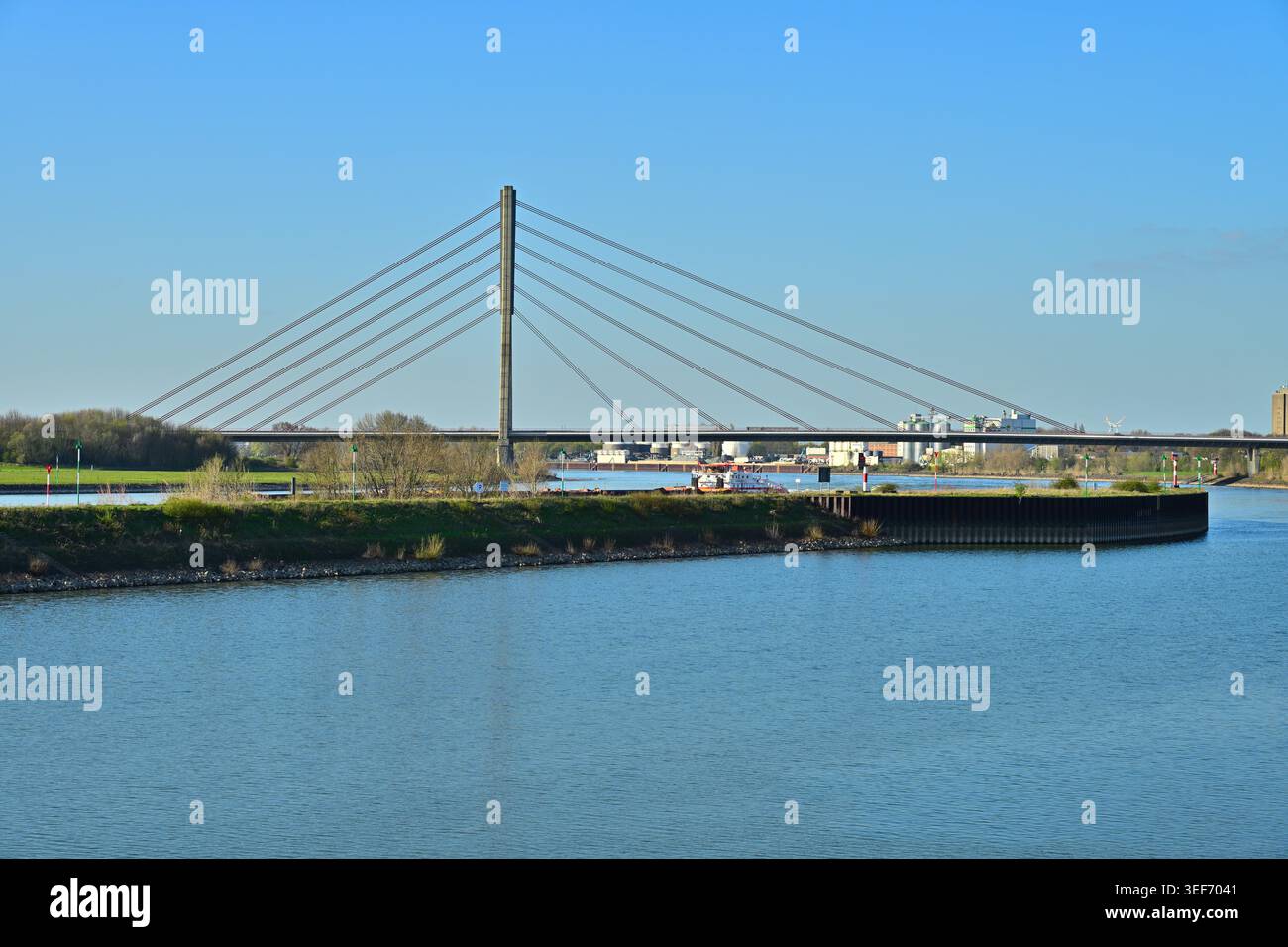 Moderne Kabelbrücke über einen breiten Fluss in Industrielandschaft Stockfoto