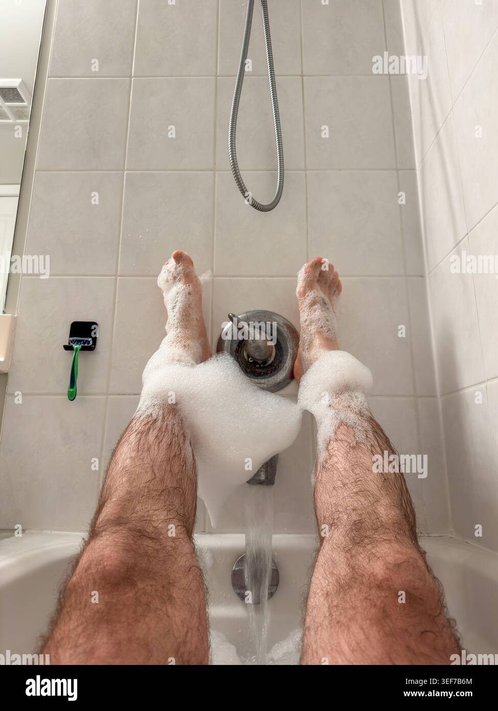 Sanfte Dusche mit sprudelnder Entspannung. Ruhiges und erfrischendes Bad mit Shampoo und sprudelnden Blasen Stockfoto