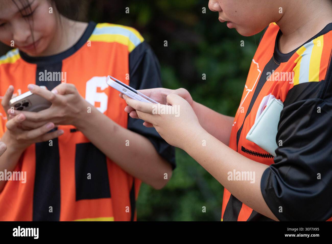 PHAYAO, THAILAND, 11. April 2026: Teenager, die Smartphones benutzen, vom mobilen Bildschirm absorbiert, fokussierter Smartphone-Nutzer, Nahaufnahme, Chiang Kham. Stockfoto