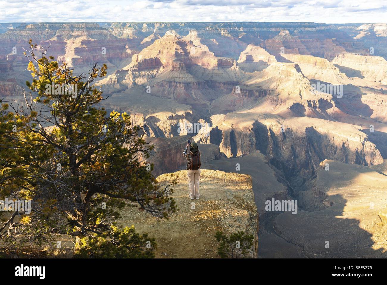 Reisende mit Rucksack genießen einen atemberaubenden Panoramablick auf den Grand Canyon National Park und erfassen die weitläufigen geologischen Formationen und die Natur Stockfoto