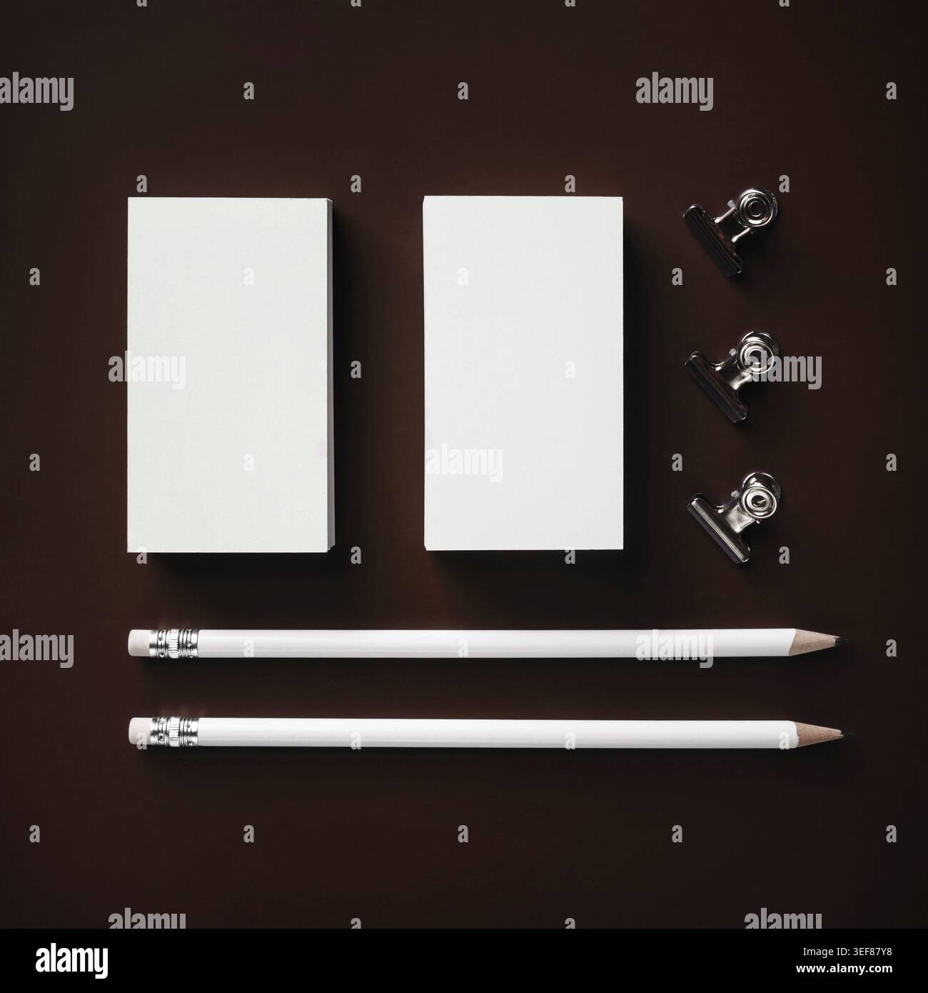 Foto von leeren Visitenkarten, Bleistiften und Binderclips. Reaktionsfreudiges Design. Flache Lagen Stockfoto
