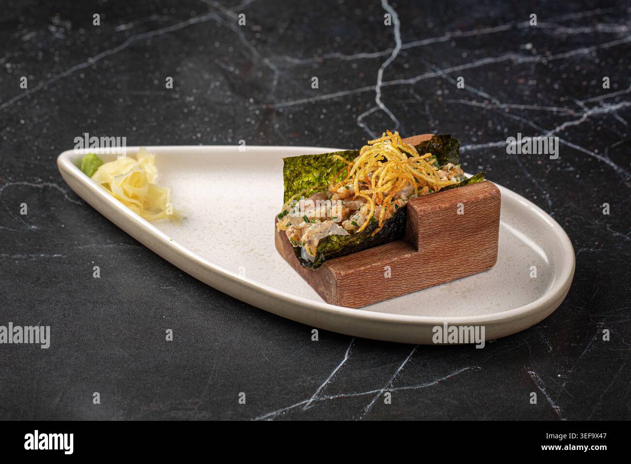 Gourmet-Handrolle mit Tatar und knuspriger Garnitur Stockfoto
