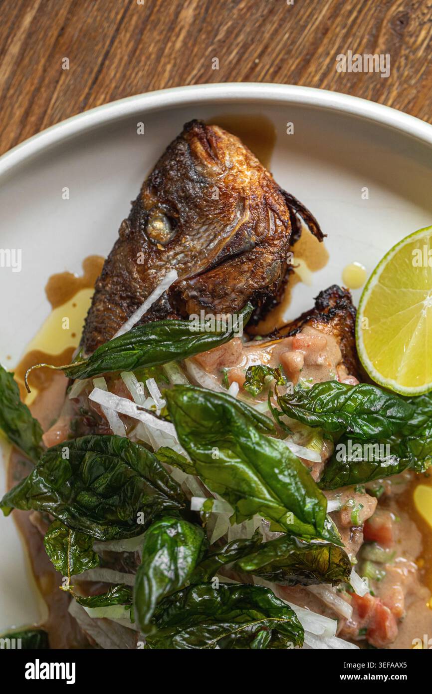 Gegrillter Fisch mit Kräutern und Limette auf Teller Stockfoto