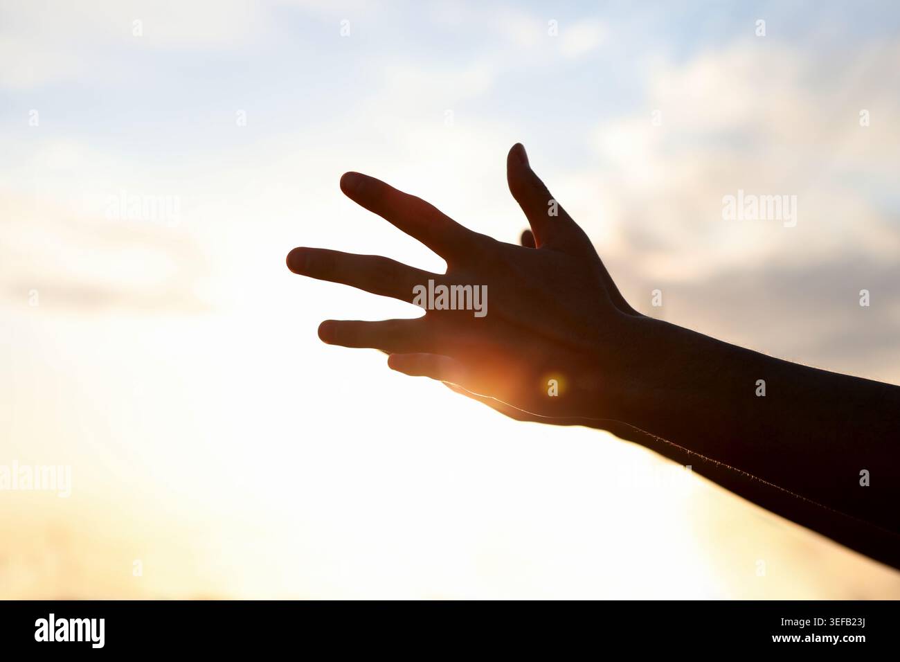 Ein symbolischer Hintergrund, der ein hoffnungsvolles Herz und einen spirituellen Glauben ausdrückt, während beide Hände zum Himmel reichen, um ernsthafte Hoffnung und pra zu erreichen Stockfoto