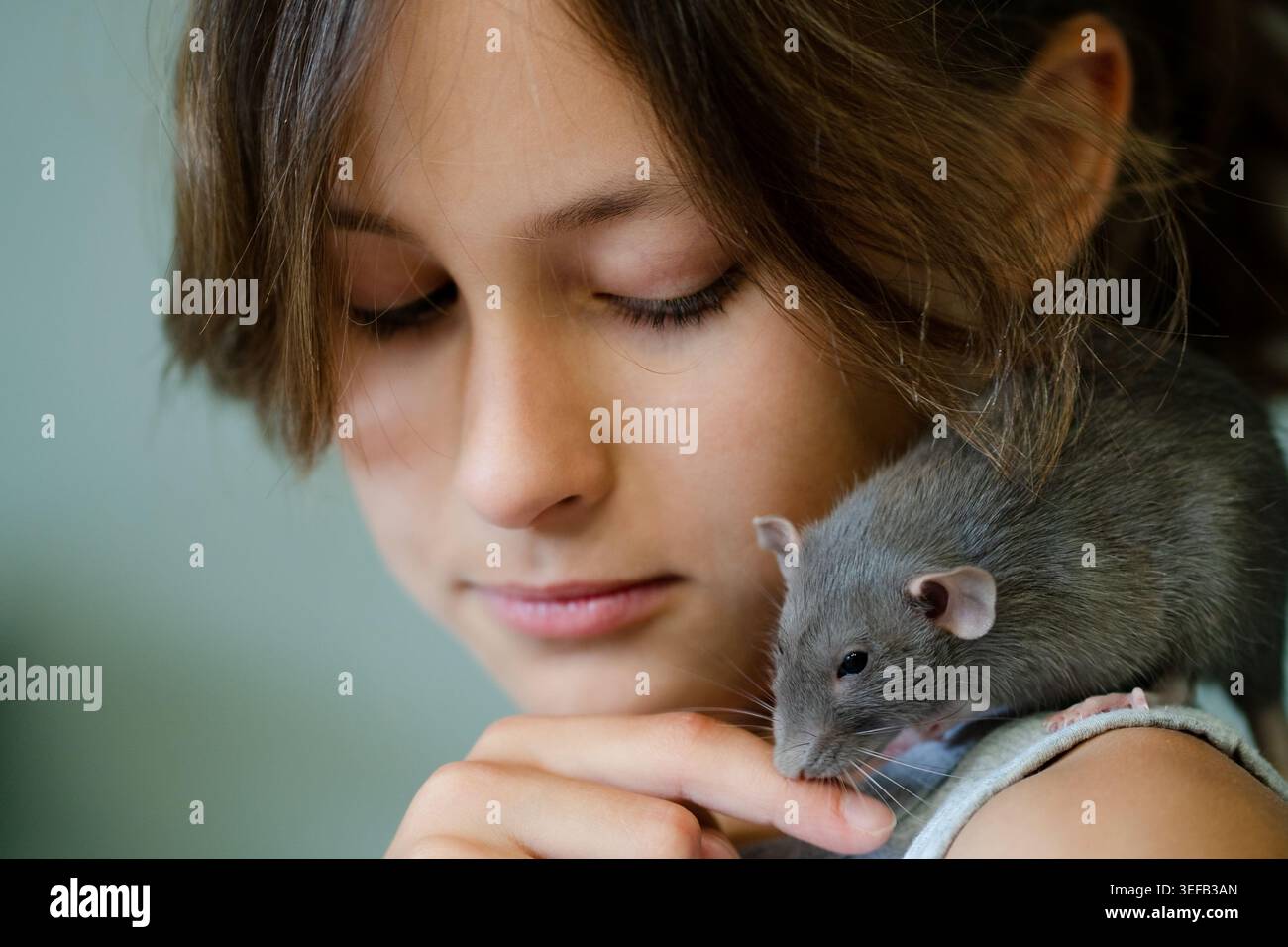 Ein Mädchen mit einem kleinen Haustier in einer fröhlichen Interaktion fängt das Glück und die spielerische Natur ein und betont die Gemeinschaft und Zuneigung Stockfoto