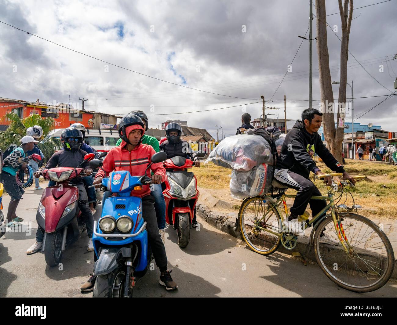 Geschäftige Straßenszene in Antanavarino Madagaskar mit Motorrädern und Fahrrädern tagsüber Stockfoto