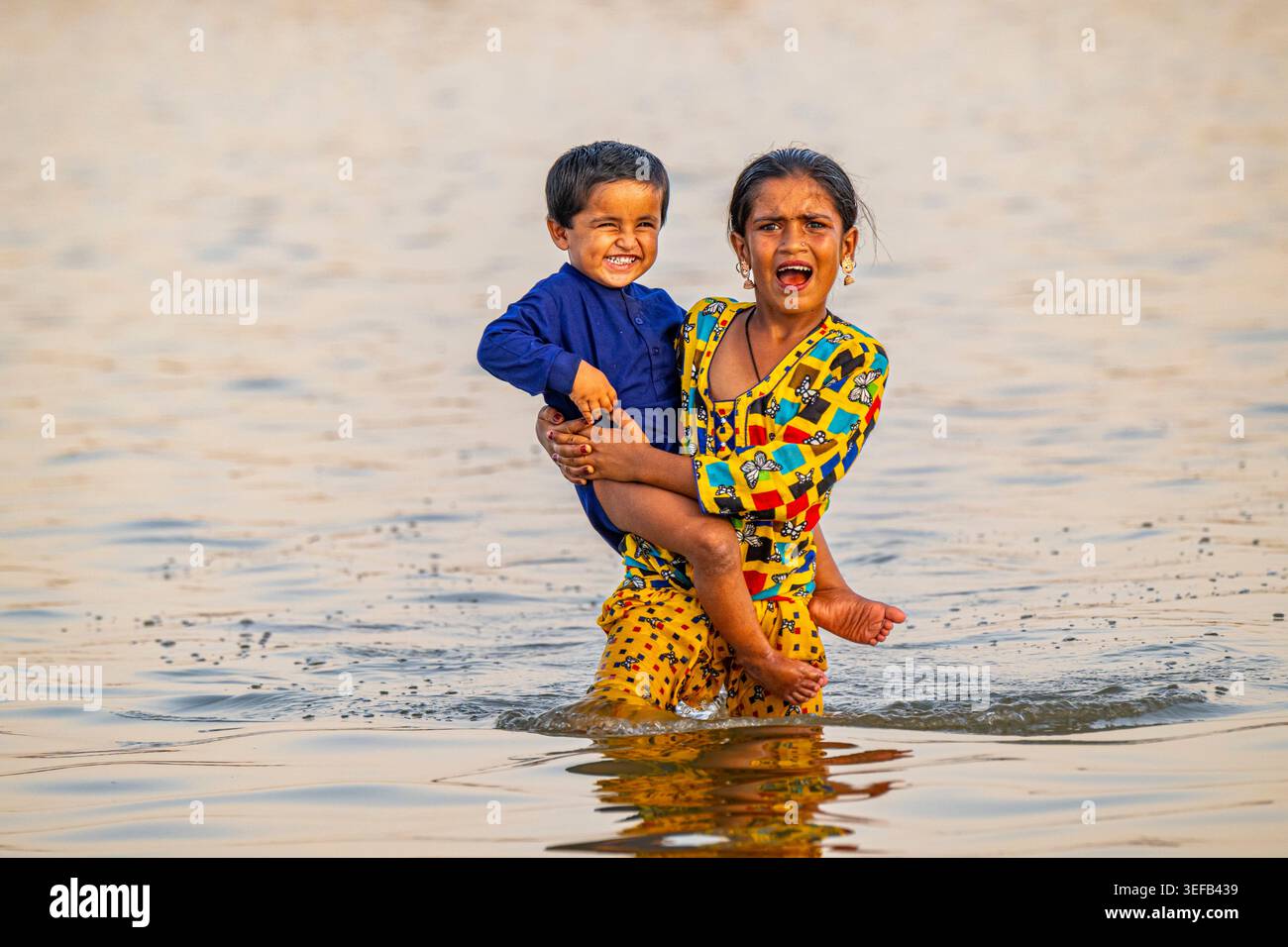 Die Geschwister der Mohana-Fischer spielen gemeinsam im Wasser am Manchar-See in Pakistan Stockfoto