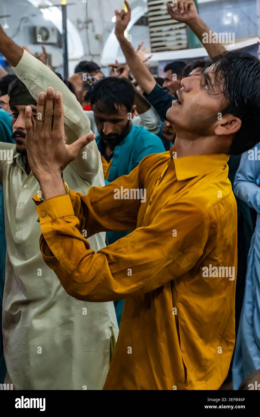 Sufi-Männer tanzen in Hingabe an einem Schrein während eines spirituellen Treffens in Sindh, Pakistan Stockfoto