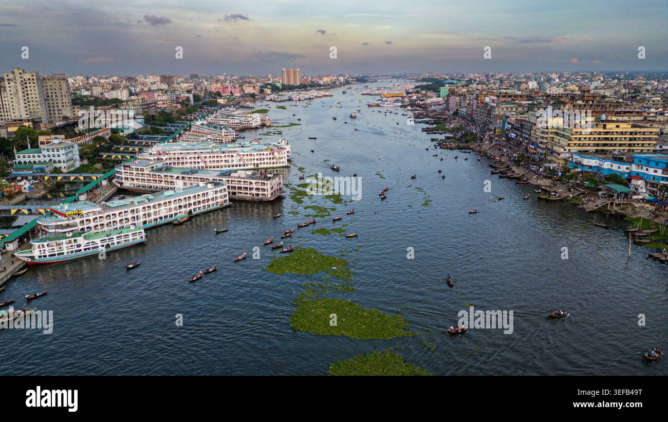 Luftaufnahme mit Booten und Gebäuden entlang des Buriganga River in Dhaka bei Sonnenuntergang in Bangladesch Stockfoto