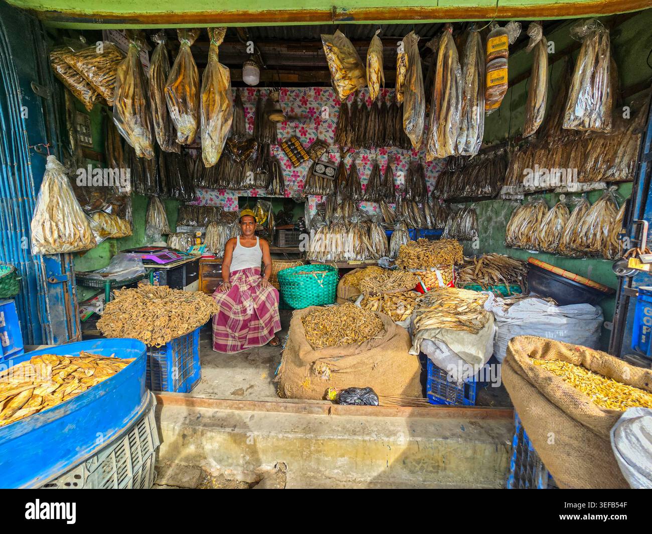 Trockenfischgeschäft in Chittagong, in dem verschiedene Fischarten und ein Verkäufer auf dem Markt angeboten werden Stockfoto