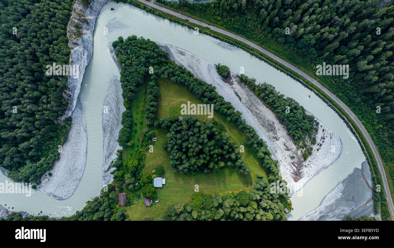 Die Luftaufnahme zeigt sich in der Schweiz mit einem gewundenen Fluss und einer grünen Landschaft Stockfoto