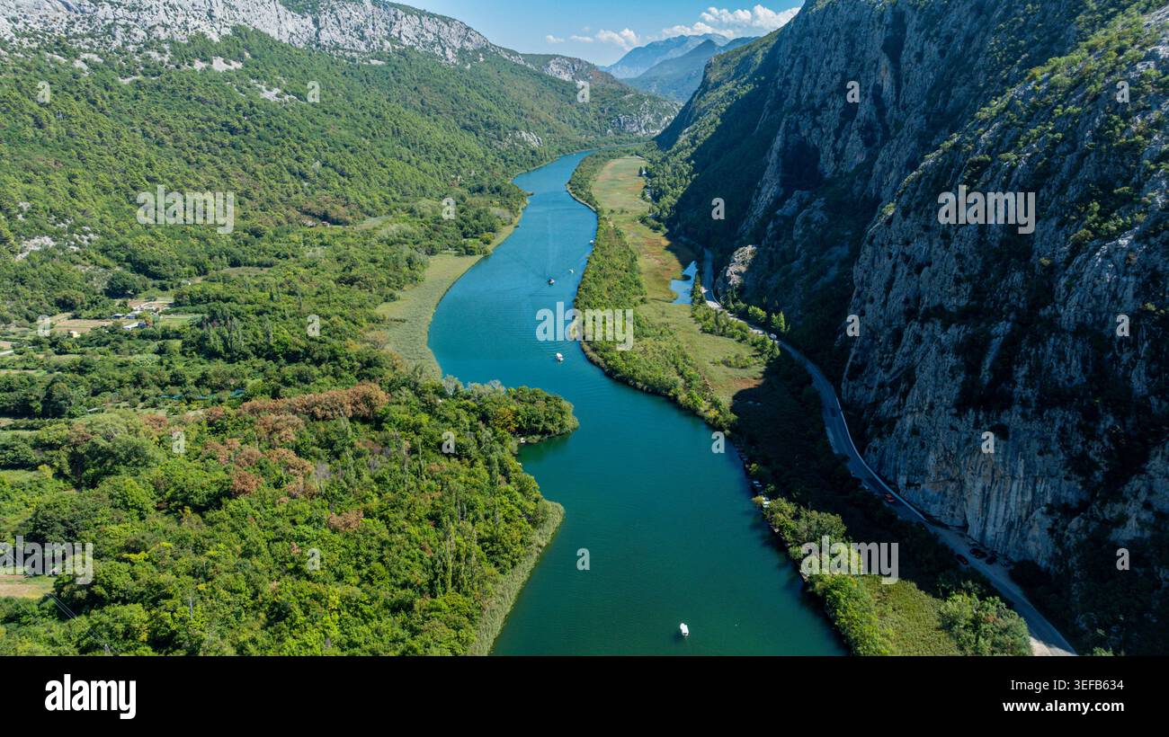 Aus der Vogelperspektive zeigt den Fluss Cetina, der sich durch die Schlucht in Kroatien mit üppigem Grün und Hügeln rund um den Wasserweg schlängelt Stockfoto