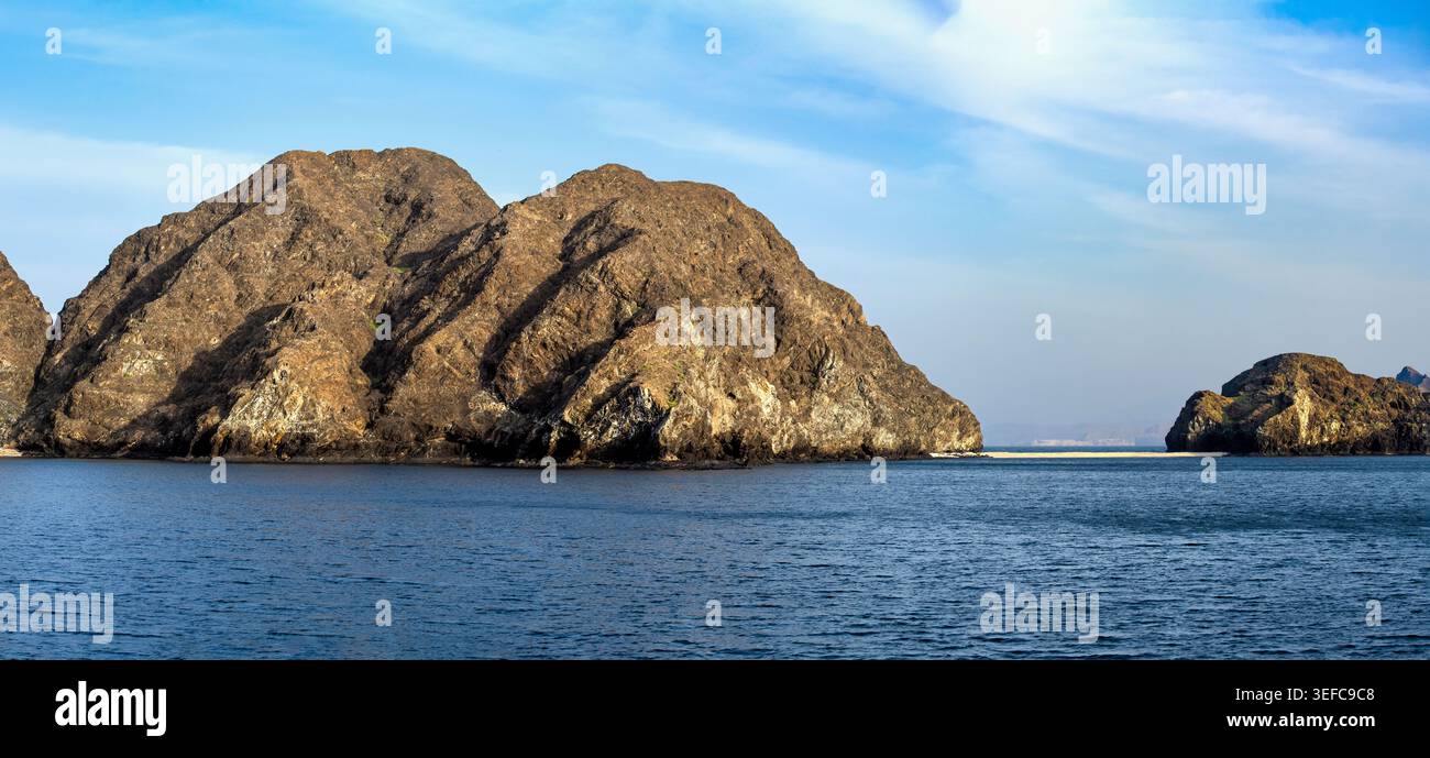 Die Küste von Oman wird von der untergehenden Sonne beleuchtet Stockfoto