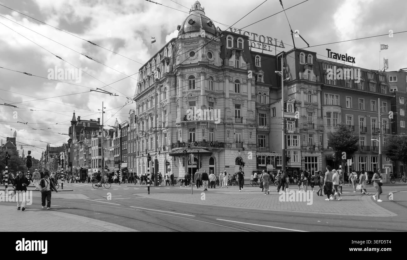 Schwarz-weiß belebte Straße vor einem historischen Hotelgebäude in Amsterdam, Niederlande. Stockfoto