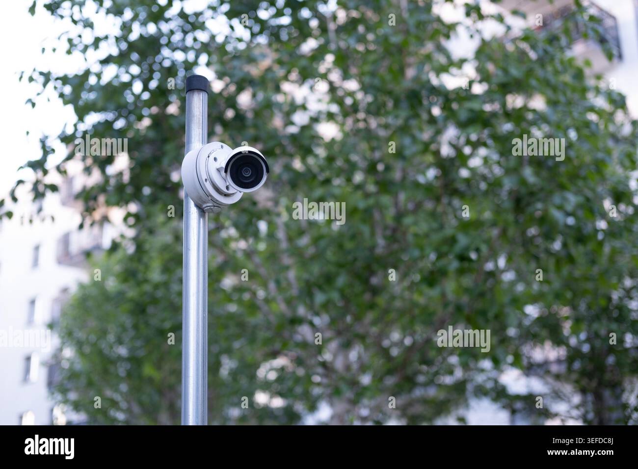 Die Überwachungskamera ist an einem Metallmast in einem öffentlichen Wohnbereich installiert. Stockfoto