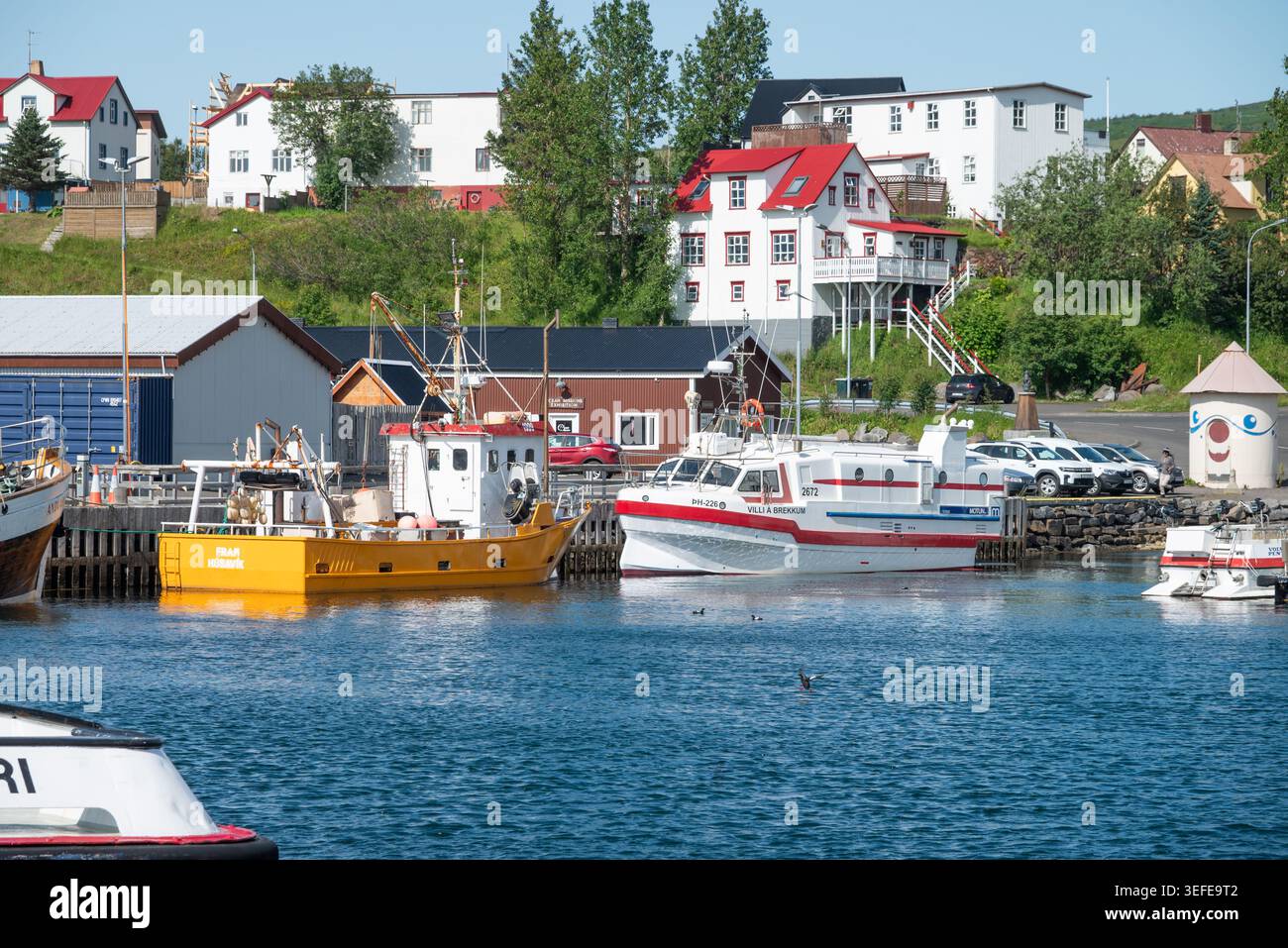 Husavik Island 6. Juli. 2025: Boote im Hafen der Stadt an einem sonnigen Sommertag Stockfoto
