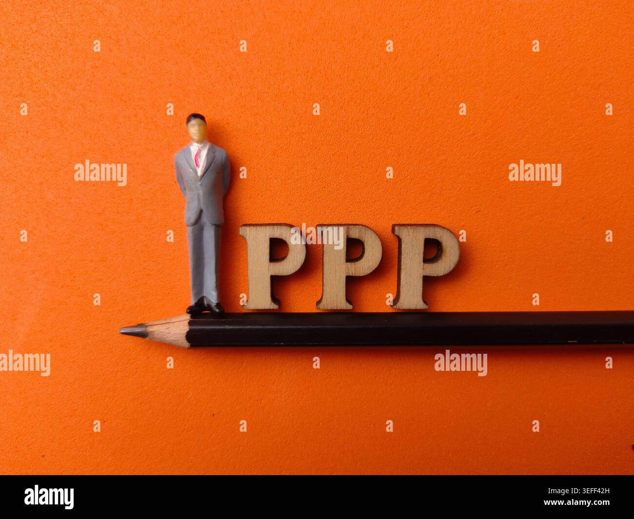 Die kleine Geschäftsmannfigur steht auf einem Bleistift neben Holzbuchstaben, die PPP auf einem orangefarbenen Hintergrund buchstabieren. Stockfoto