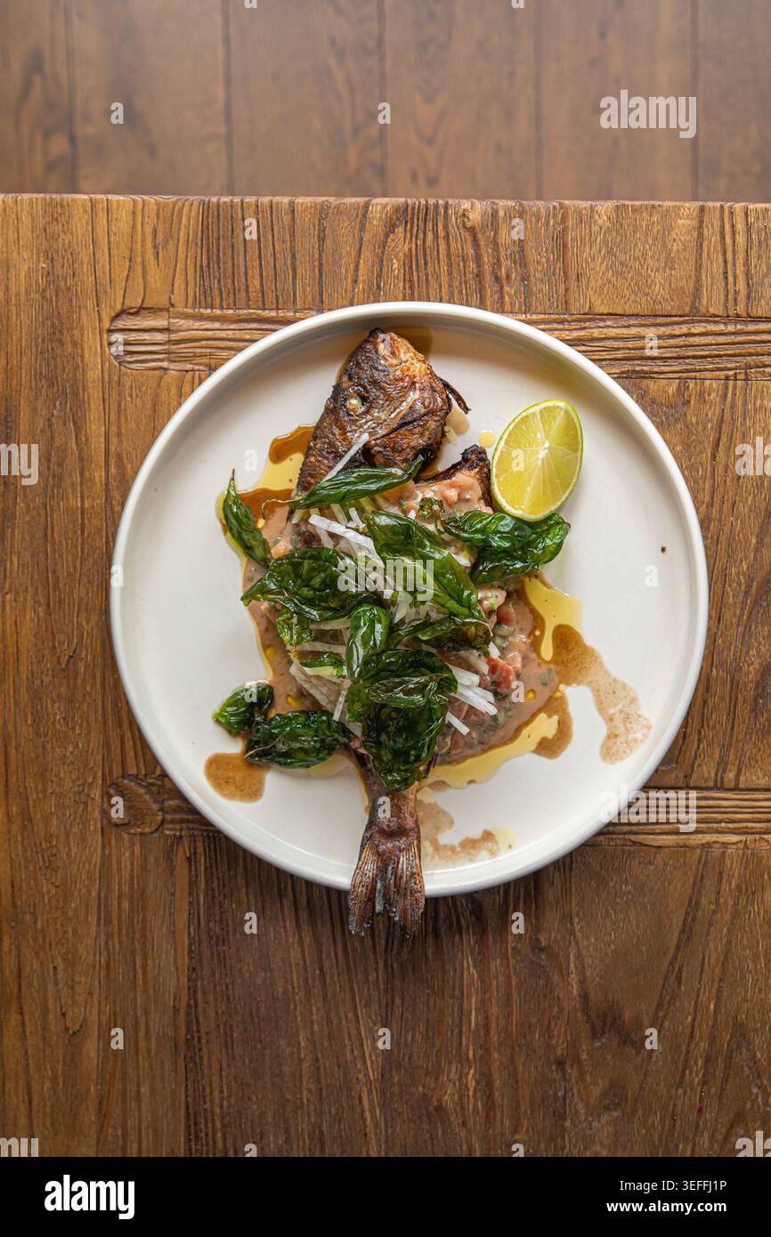 Gegrillter Fisch mit Kräutern und Limette auf Teller Stockfoto