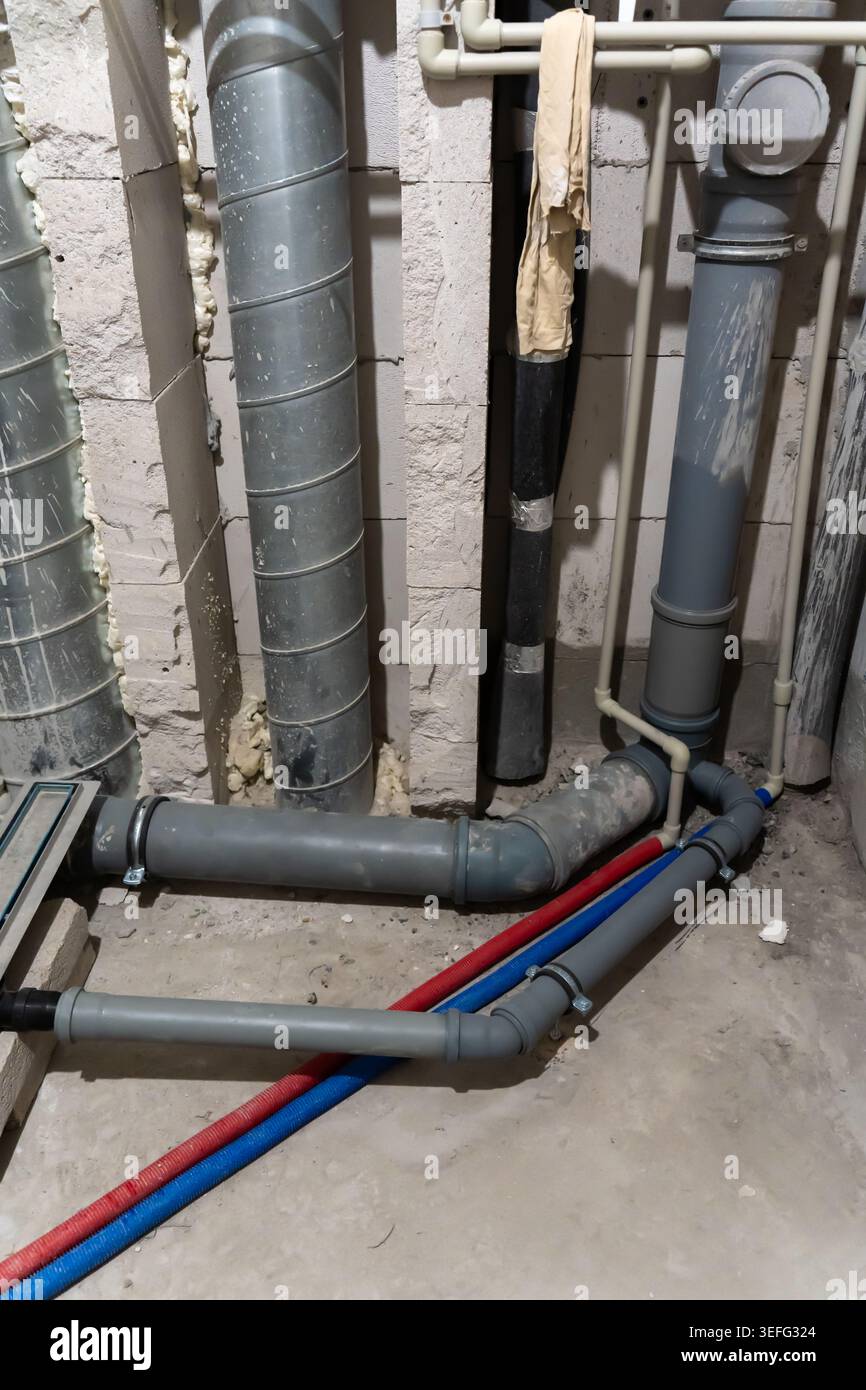 Professionelle Sanitäranlage für ein modernes Badezimmer mit sichtbaren Steigrohren und Abwasserabflusssystem. Diese Aufnahme stellt eine hochwertige Konstruktion dar Stockfoto