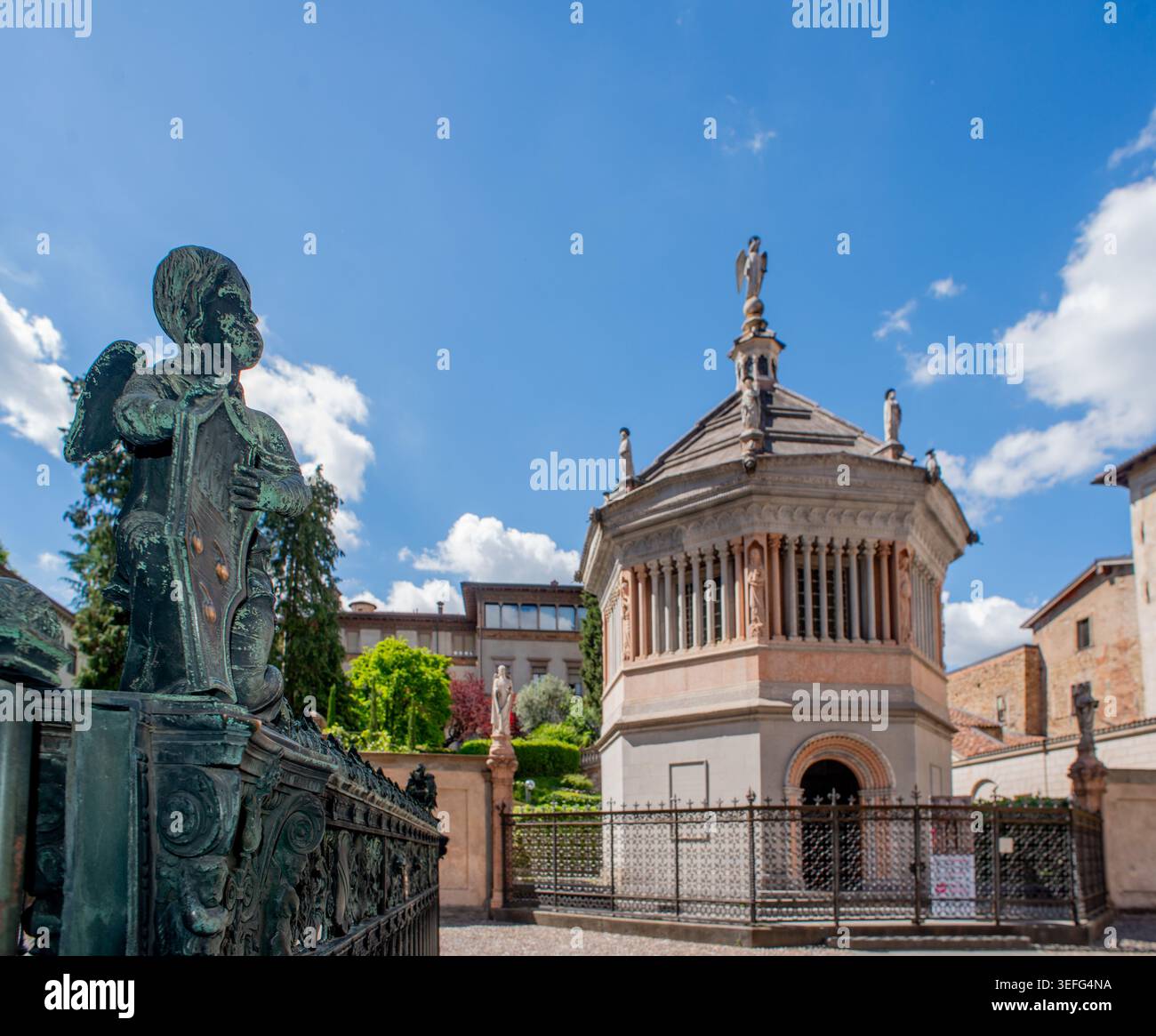 Ein historischer Blick auf Bergamo Alta: Das Baptisterium und den Glockenturm von Campanone unter dem Frühlingshimmel. Stockfoto