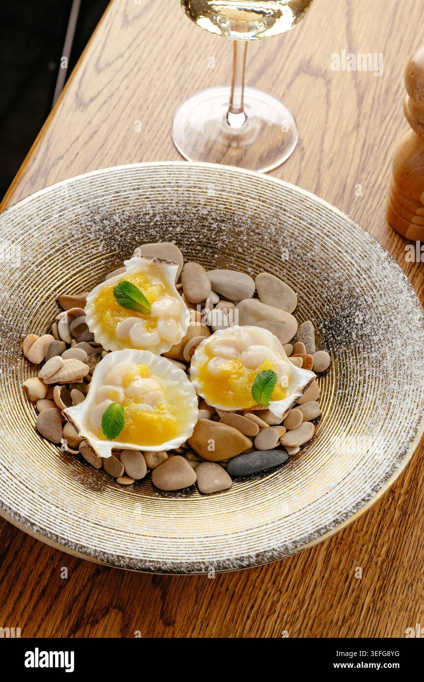 Gourmet-Vorspeise mit Jakobsmuscheln serviert mit Weißwein Stockfoto