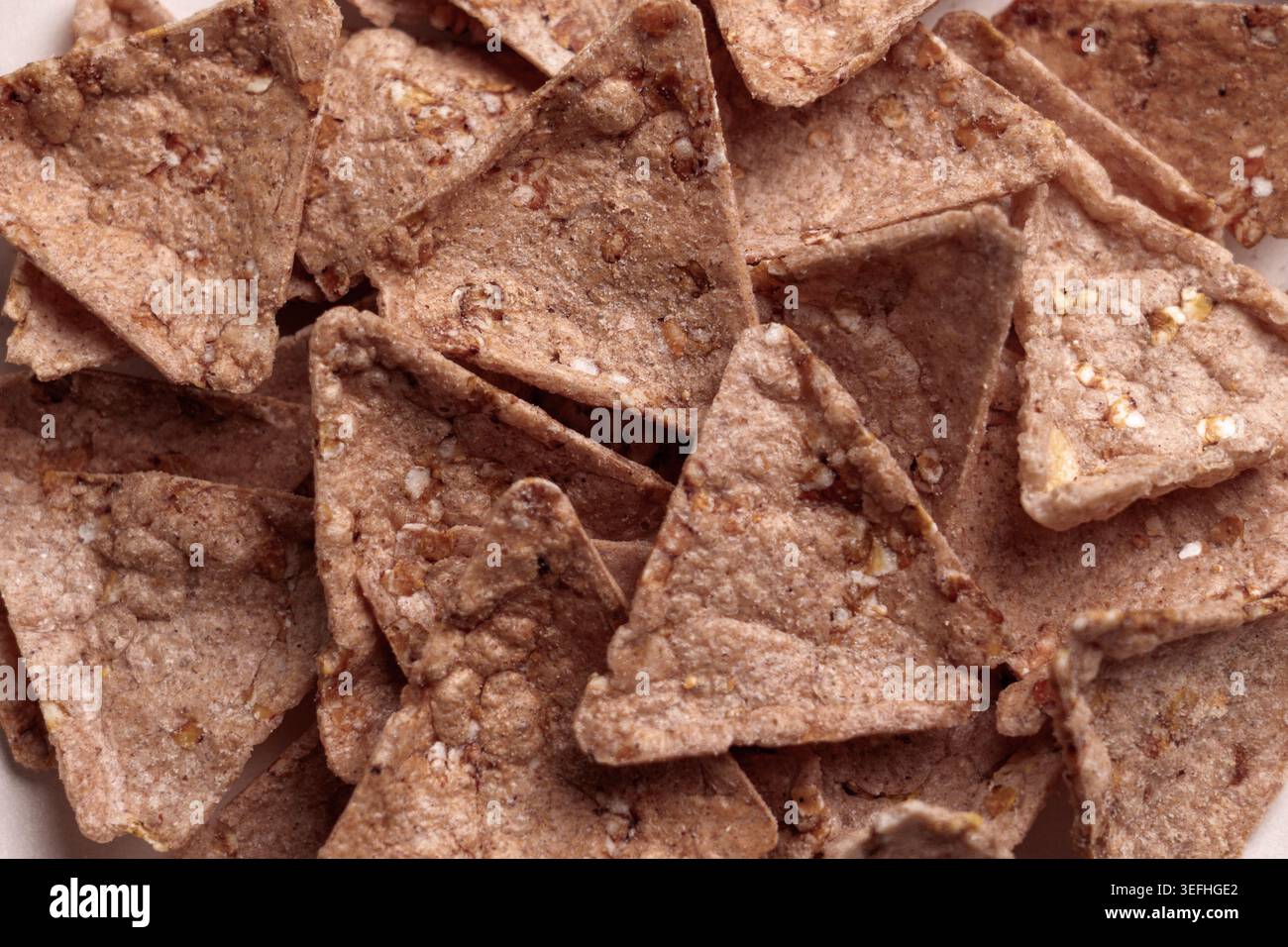 Knusprige Bio-Buchweizen-Nachos mit Amaranth und Quinoa. Dreieckige Tortilla-Chips mit knuspriger Textur. Glutenfreier Snack. Draufsicht. Stockfoto