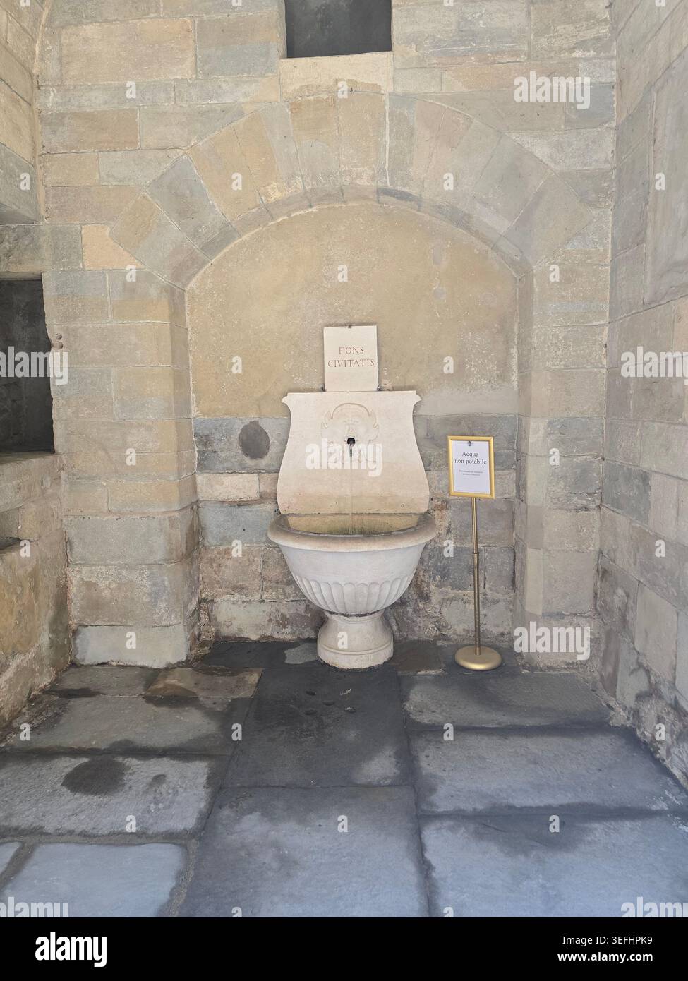 Ein traditioneller Trinkbrunnen aus Stein in einer geschnitzten Nische in den Mauern von Bergamo Alta, der historischen Oberstadt der Lombardei, Italien - Smartphone-aufgenommenes Stockfoto