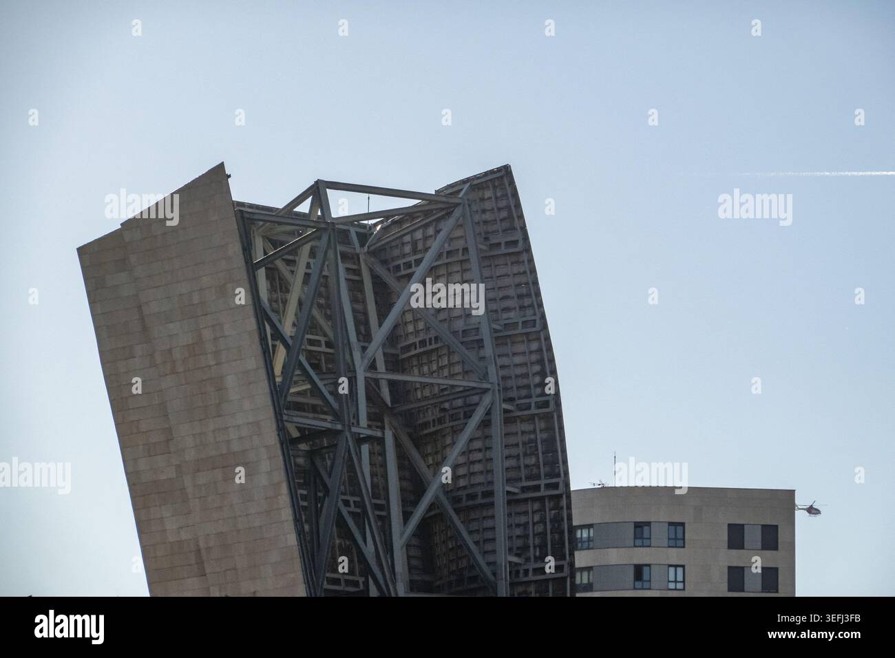 Blick auf das moderne Metallgestell und die Steinplatten des Guggenheim Museums Bilbao unter einem klaren blauen Himmel in Bilbao, Euskadi, Spanien. Stockfoto
