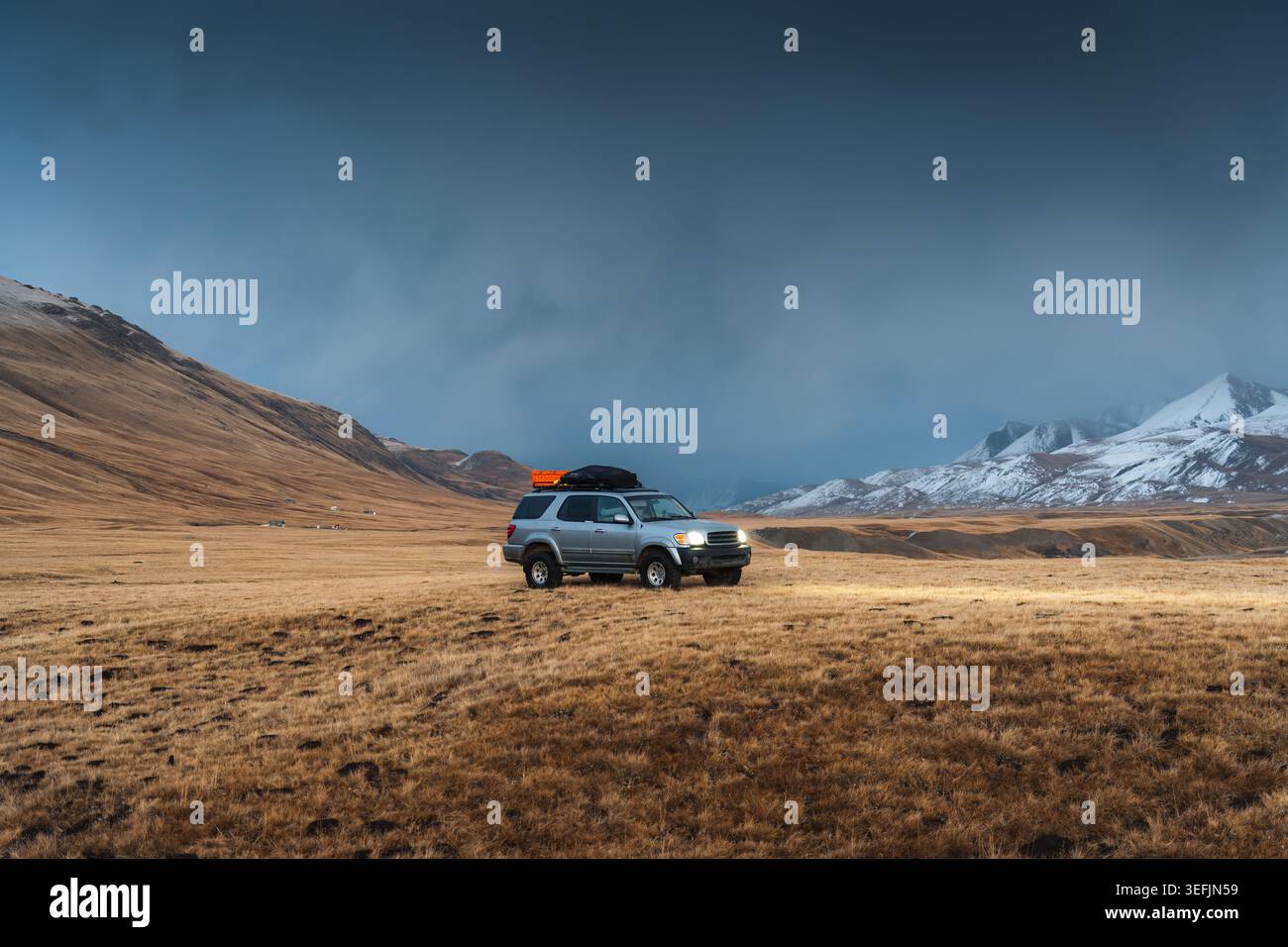 Abenteuer-Expedition Offroad-Fahrzeug im majestätischen Sary Jaz-Tal mit Gebirgszügen und weitläufiger Landschaft im Herbst in Kirgisistan Stockfoto