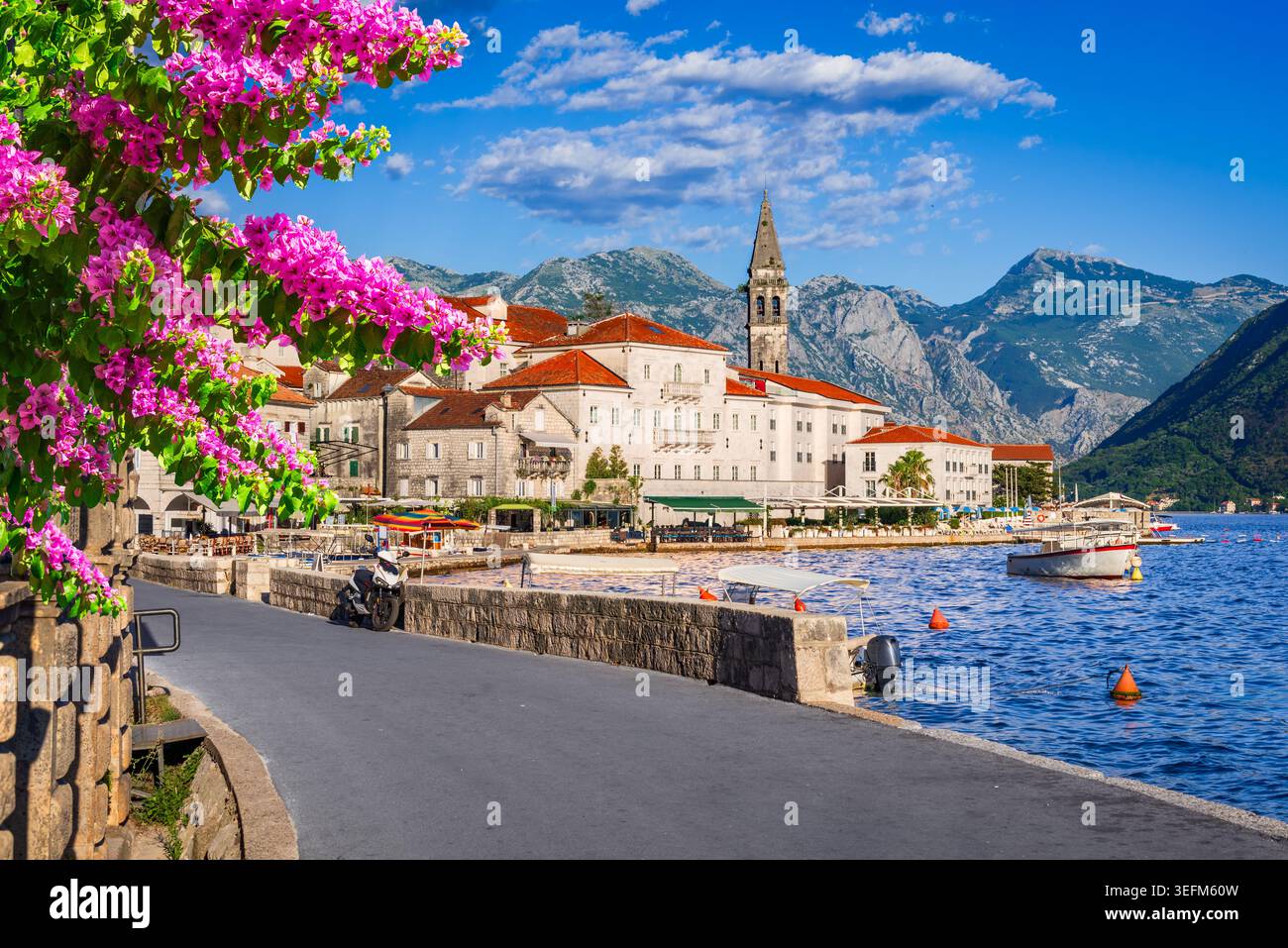 Perast, Montenegro. Die Stadt am Hügel hebt den hohen Kirchturm entlang der Bucht von Kotor hervor. Stockfoto