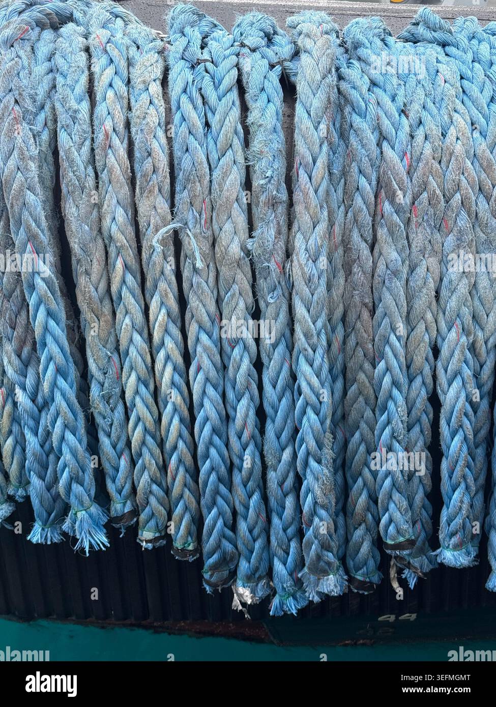 Nahaufnahme von dicken, blau geflochtenen maritimen Anlegeseilen, die in einem Hafen in Nassau, Bahamas, zusammengestapelt sind. Stockfoto
