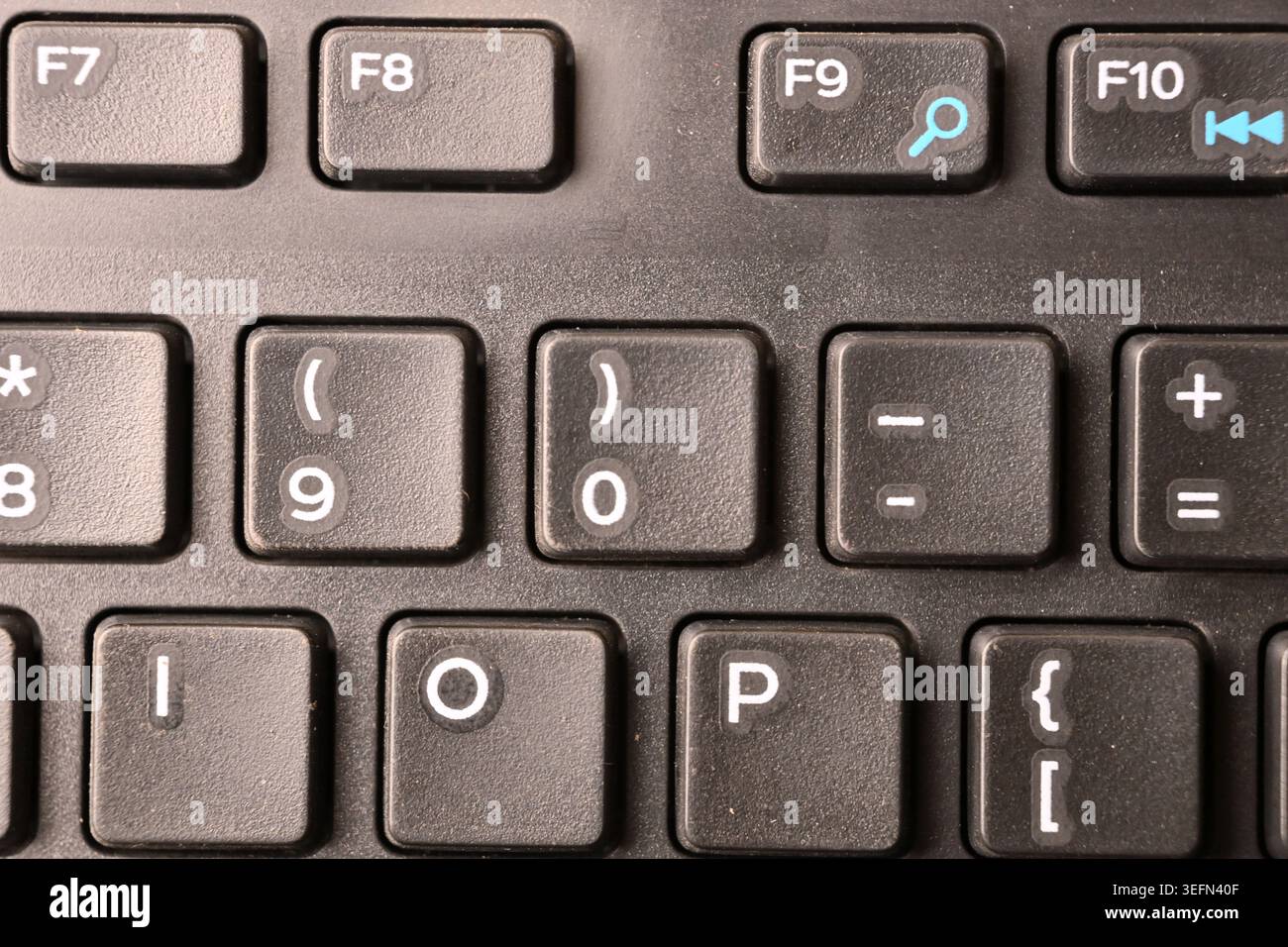 Schwarze Computertastatur Makroaufnahme mit Hervorhebung von 0 und rechter Klammer mit weichem, verschwommenem Hintergrund Draufsicht Stockfoto