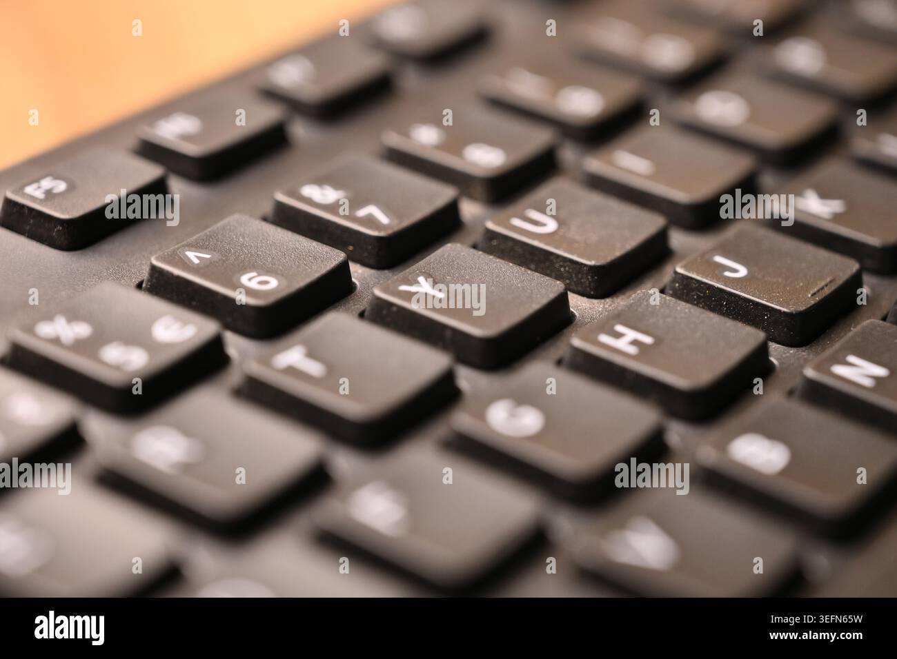 Makro Draufsicht Schwarze Computertastatur mit gelber „Y“-Taste auf verschwommenem Hintergrund Close-up Tech Concept Stockfoto