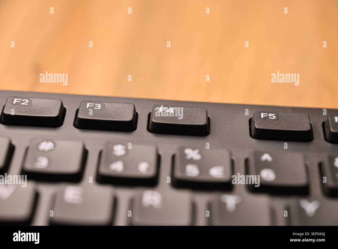 Minimale schwarze Tastatur-Makrokompositionen zur Hervorhebung der Funktionstaste F4 in der schrägen Draufsicht des Weichfokus Stockfoto