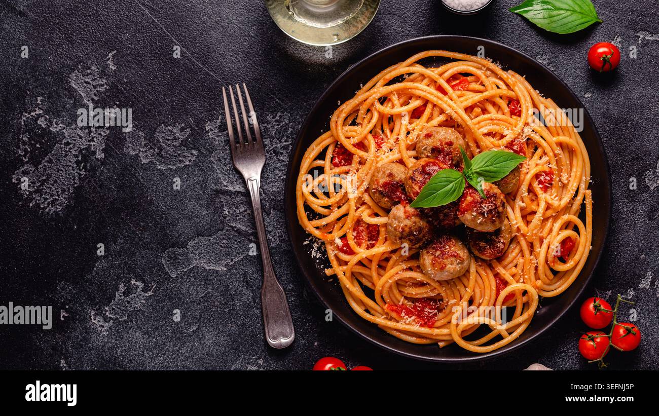 Spaghetti mit Fleischbällchen und Tomatensauce auf Steinhintergrund, Draufsicht Stockfoto