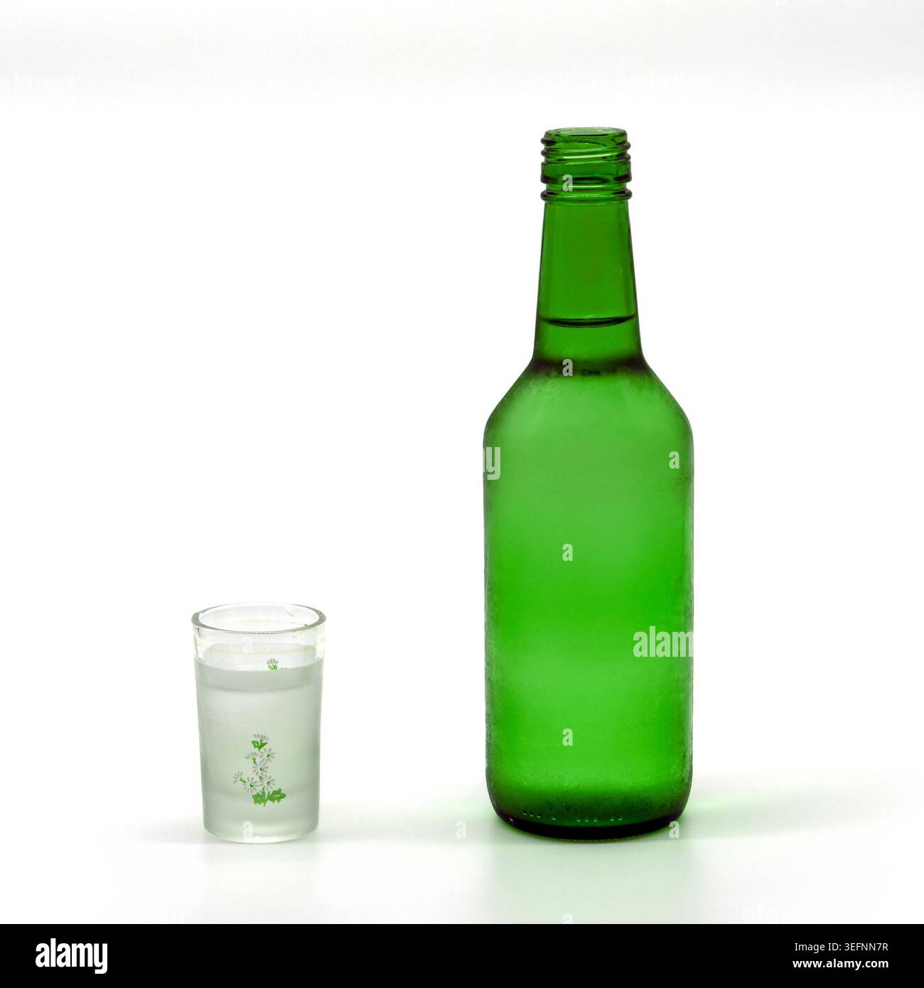 Eine gekühlte Flasche Soju und ein gefülltes Shot-Glas Stockfoto