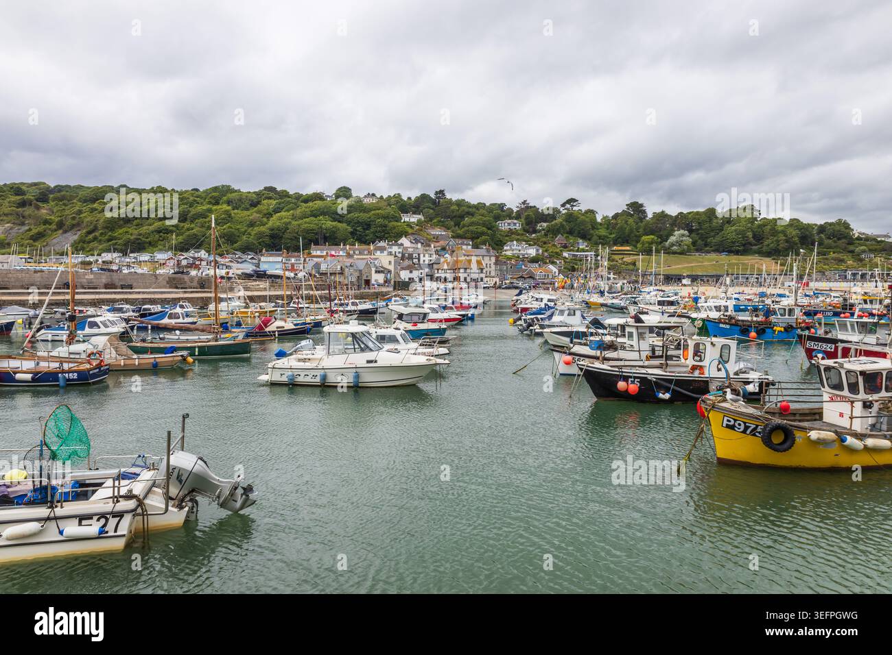 Küstenblick auf den Hafen von Lyme Regis mit Fischerbooten und Stadt. Lyme Regis, UK, 3. Juli 2024 Stockfoto