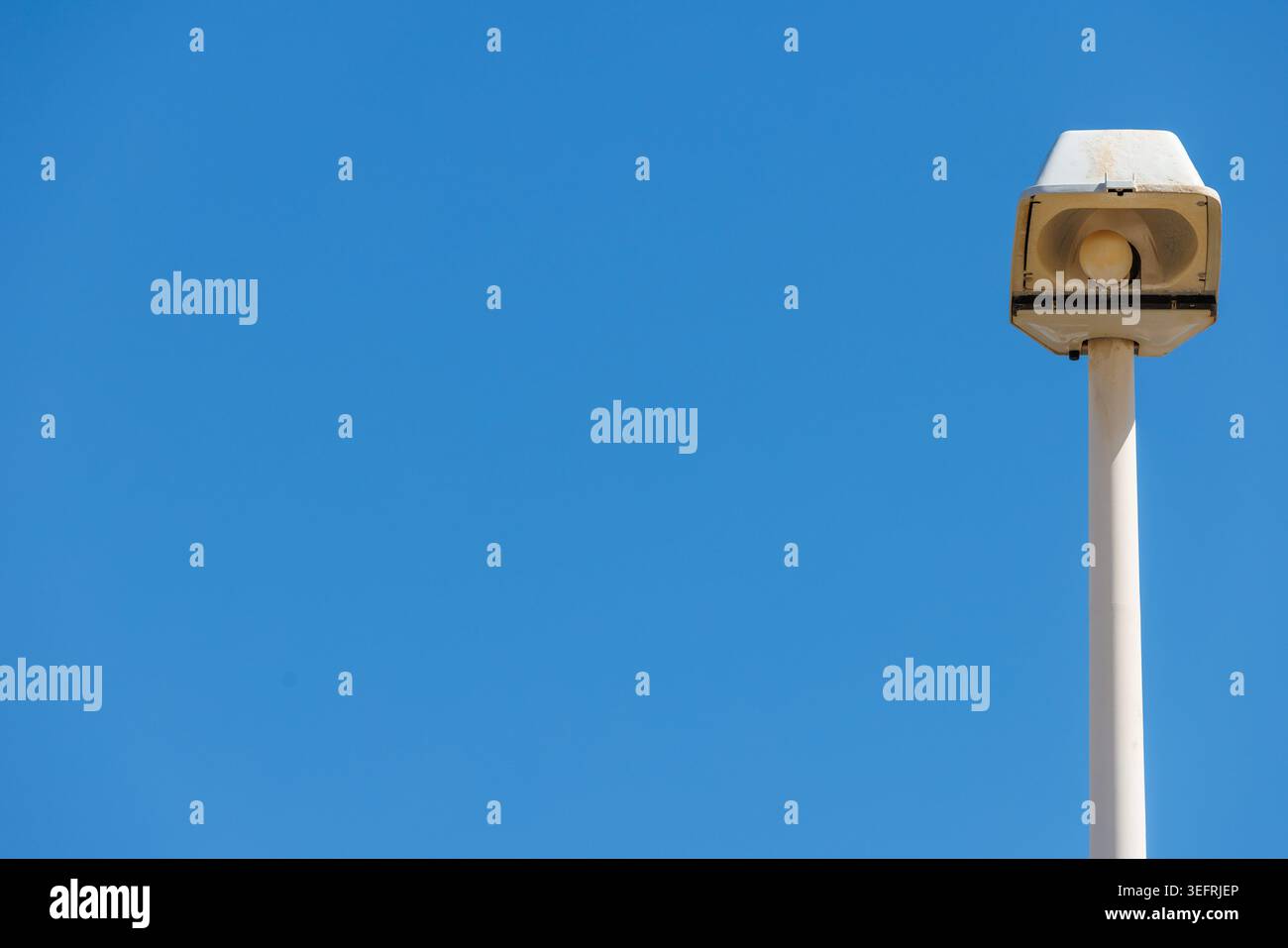 Blauer Himmel Hintergrund mit Straßenlaterne auf der rechten Seite und minimaler Textur. Stockfoto