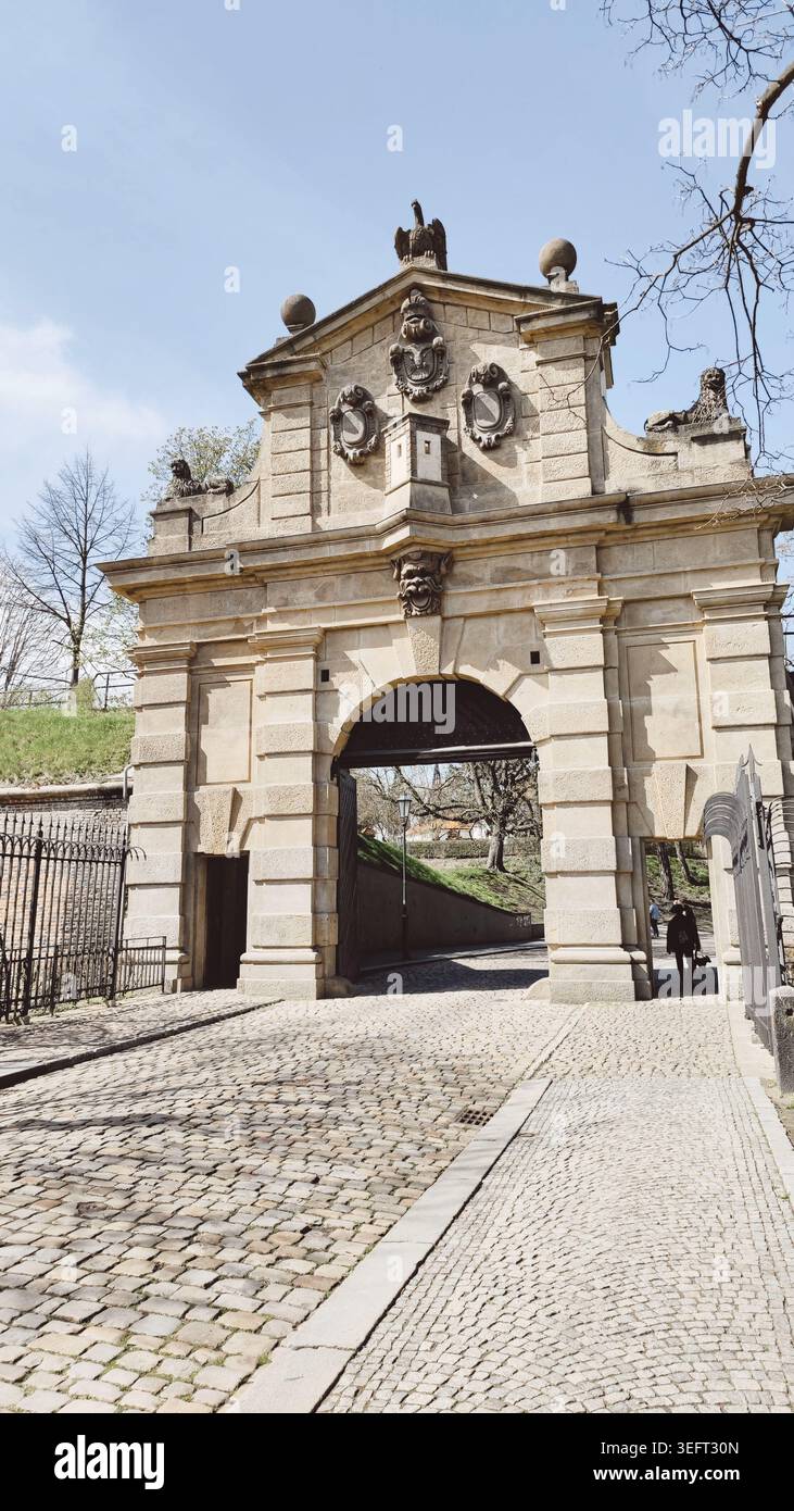 Prag, Tschechische Republik, verziertes Vysehrader Tor mit gewölbtem Eingang, Kopfsteinpflasterweg, dekorative Skulpturen A Stockfoto