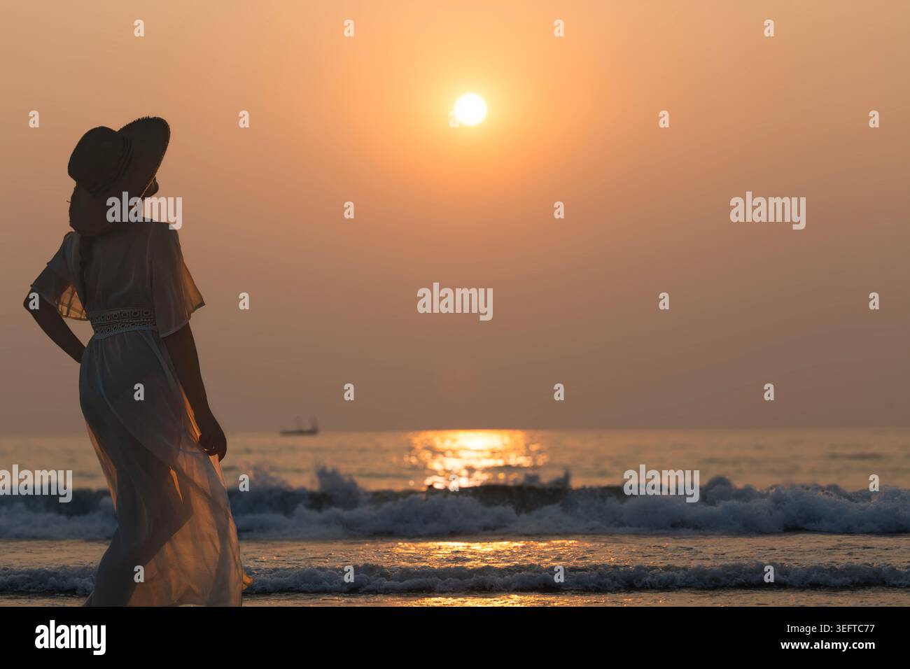 Touristin posiert bei Sonnenuntergang am Anjuna Beach in Nord-Goa, Indien Stockfoto