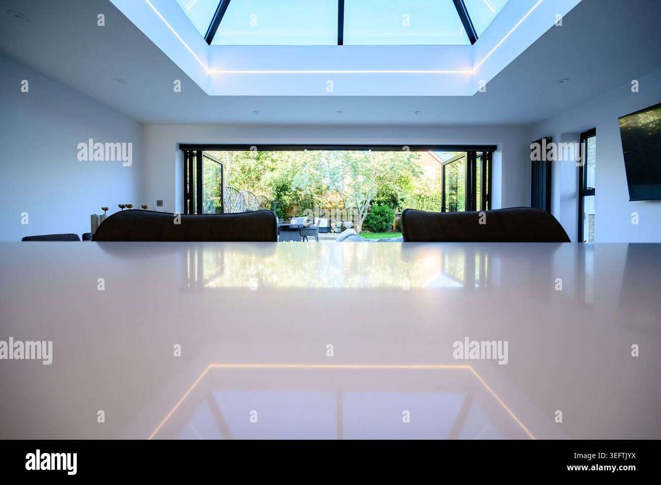 Ein modernes Oberlicht reflektiert auf einer großen Quarzküche Insel Stockfoto