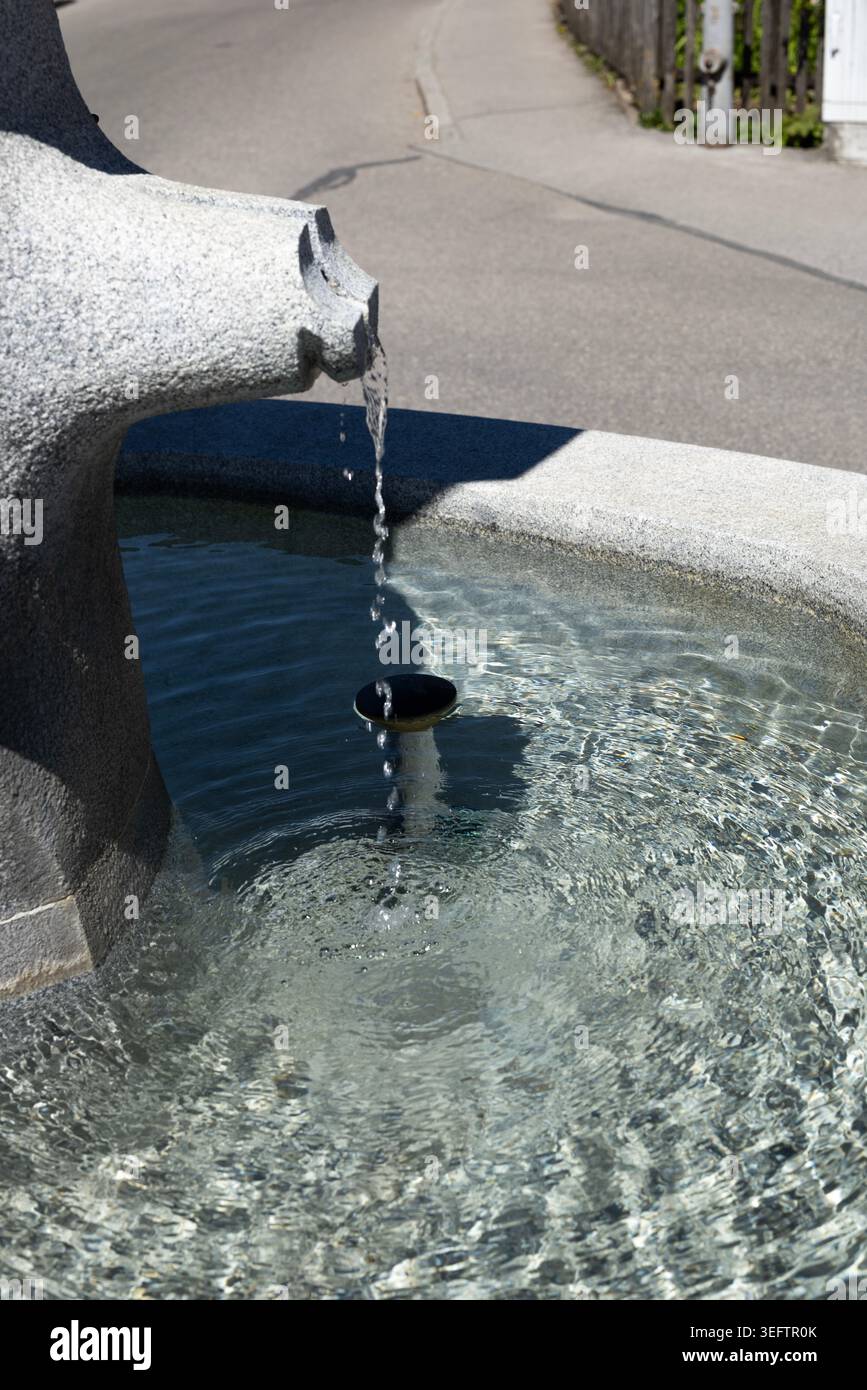 Klares Wasser fließt aus dem historischen Steinbrunnen in Bayern Stockfoto
