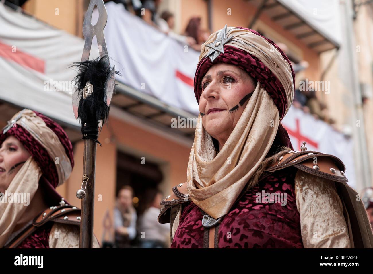 Frau in traditioneller Tracht lächelt während des Maurischen Paradewettbewerbs in den Festlichkeiten von Alcoy, 25. April 2026 Stockfoto
