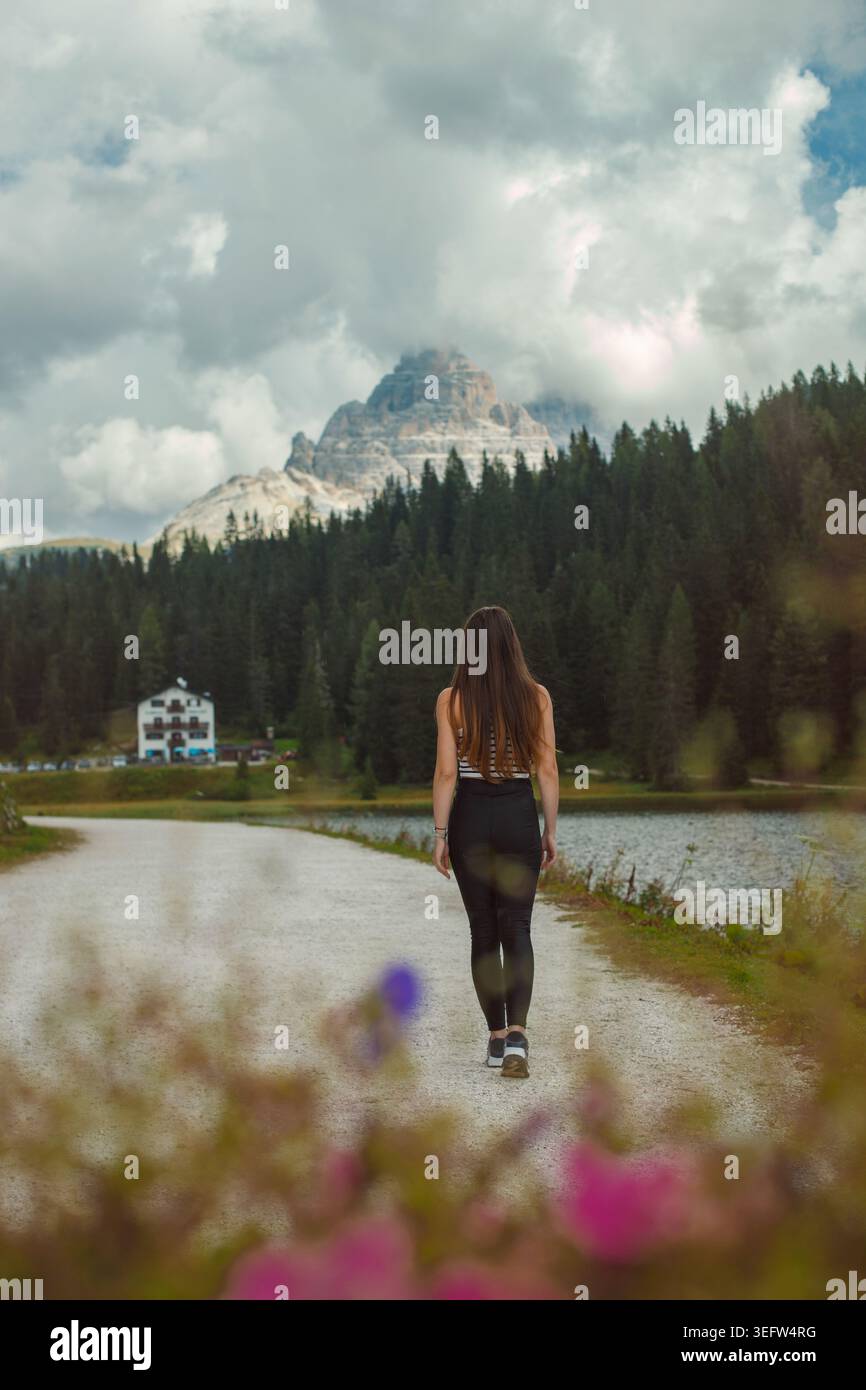 Frau, die auf dem Landweg des Sees in den dolomiten läuft Stockfoto