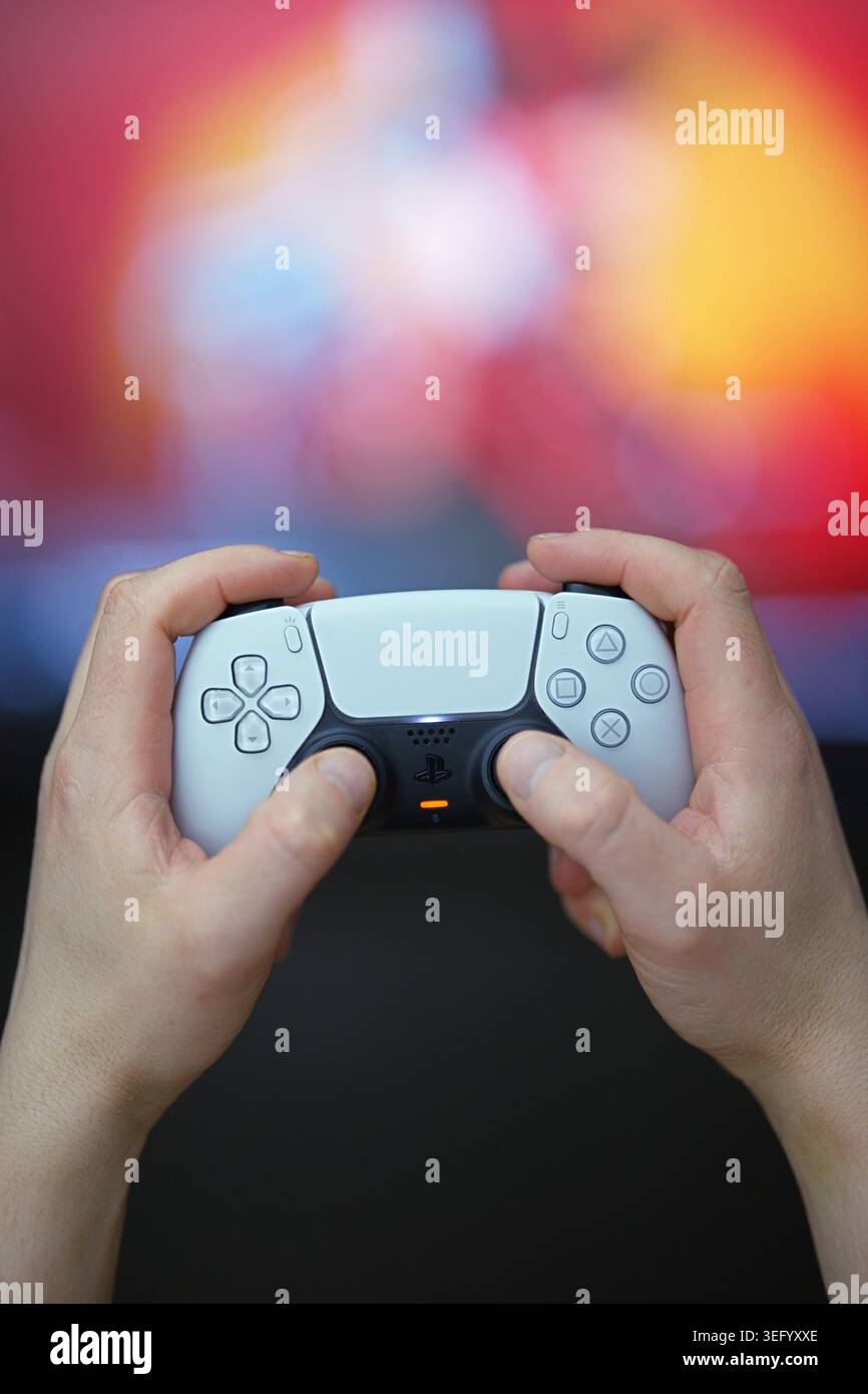 Gorzow Wielkopolski, Polen, 05.16.2026 Eine Nahaufnahme eines weißen Sony PlayStation 5 DualSense Gamecontrollers in den Händen eines Mannes Stockfoto