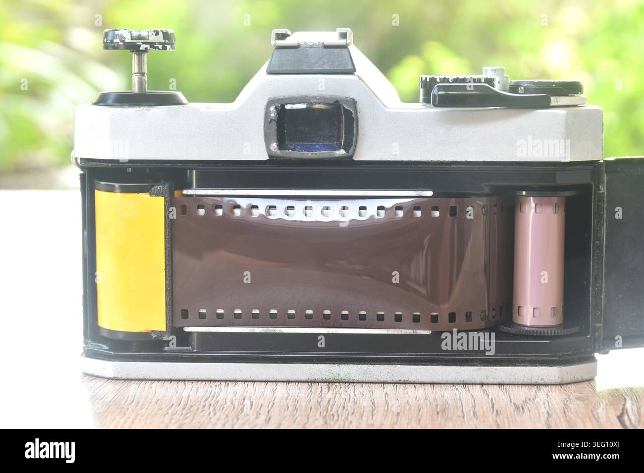 Manuelles Einlegen von Negativfilm auf eine einzelne Linse reflektiert in der hinteren Abdeckung Stockfoto