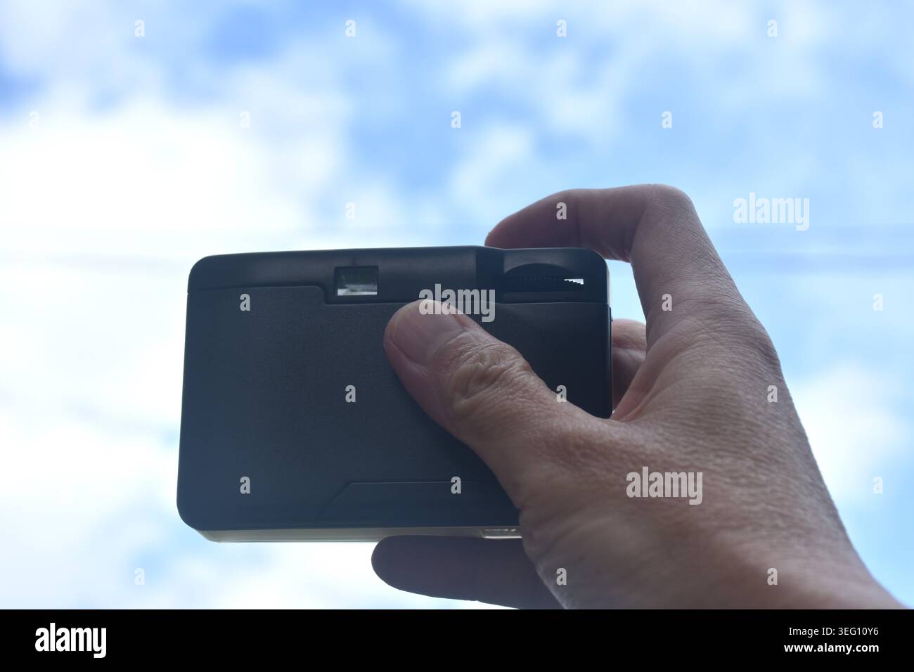 Handfotografie mit manueller Kompaktkamera mit hellem Himmel Hintergrund und Textur Stockfoto