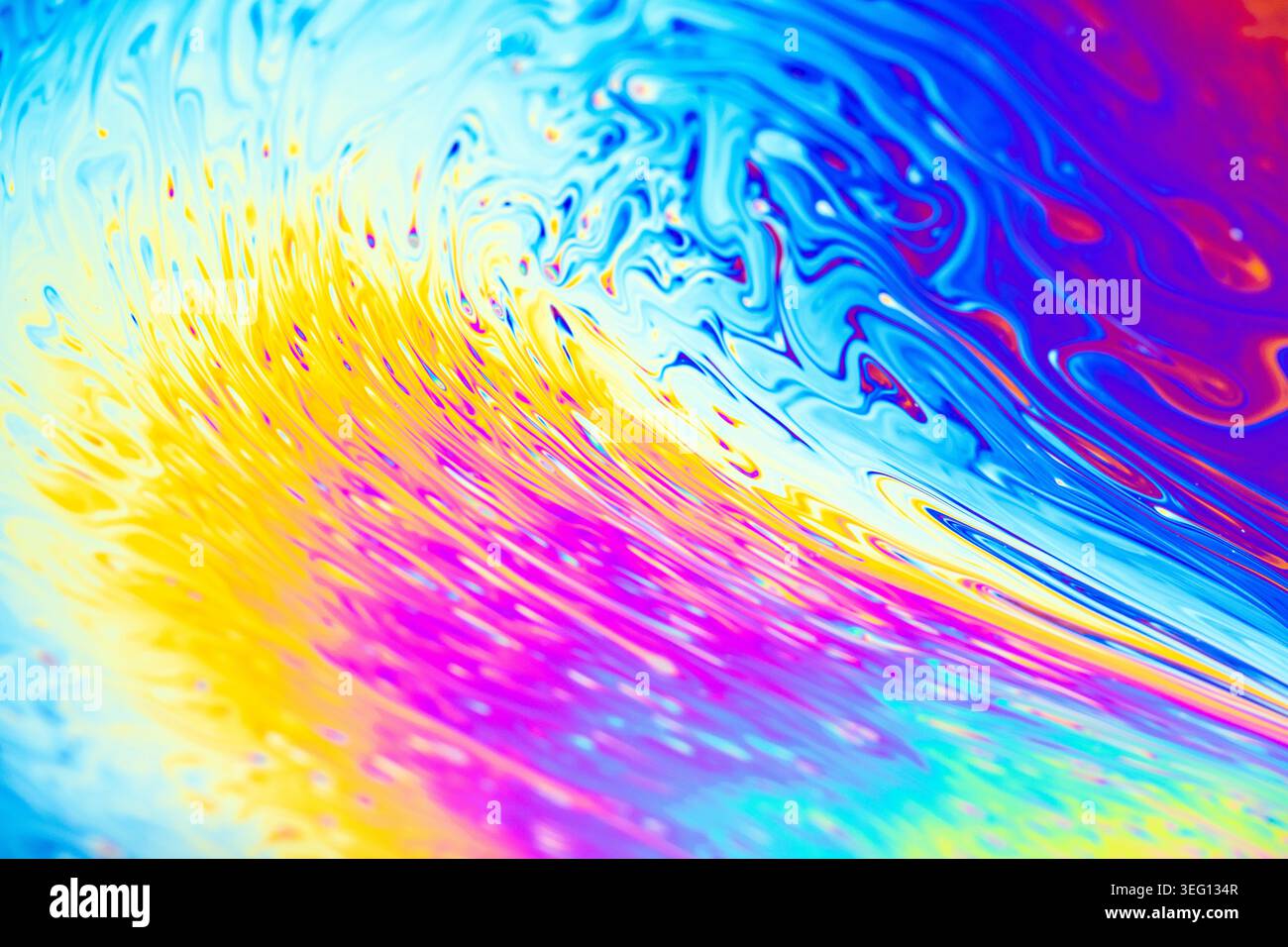 Nahaufnahme eines irisierenden Seifenfilms, der Interferenzmuster in hellen Farben wie Gelb, Rosa und Blau zeigt Stockfoto