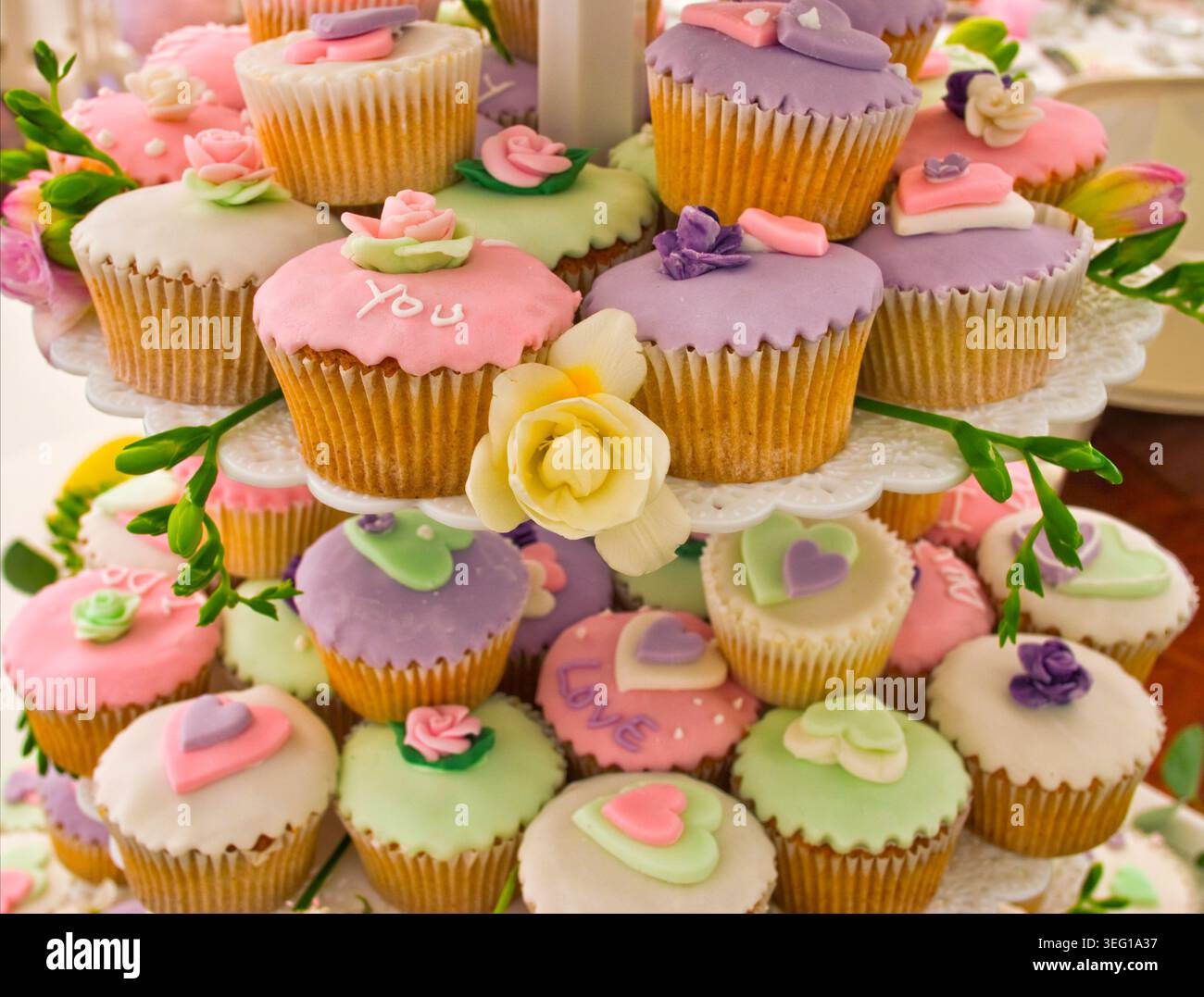 Hochzeitstorte bestehend aus Feenkuchen oder Cupcakes mit Herzen und Paspelbotschaften. Stockfoto