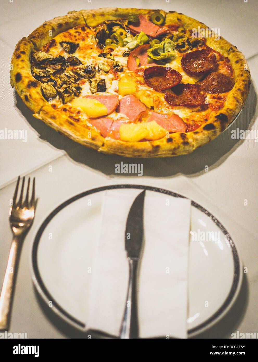 Eine Kombination aus Capricciosa, Salami, hawaiianischen und Pilzen in einer handgefertigten Pizza Stockfoto